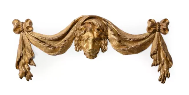 A CARVED GILTWOOD WALL MOUNT DISPLAY OF A LION HEAD AND SWAGS, LATE