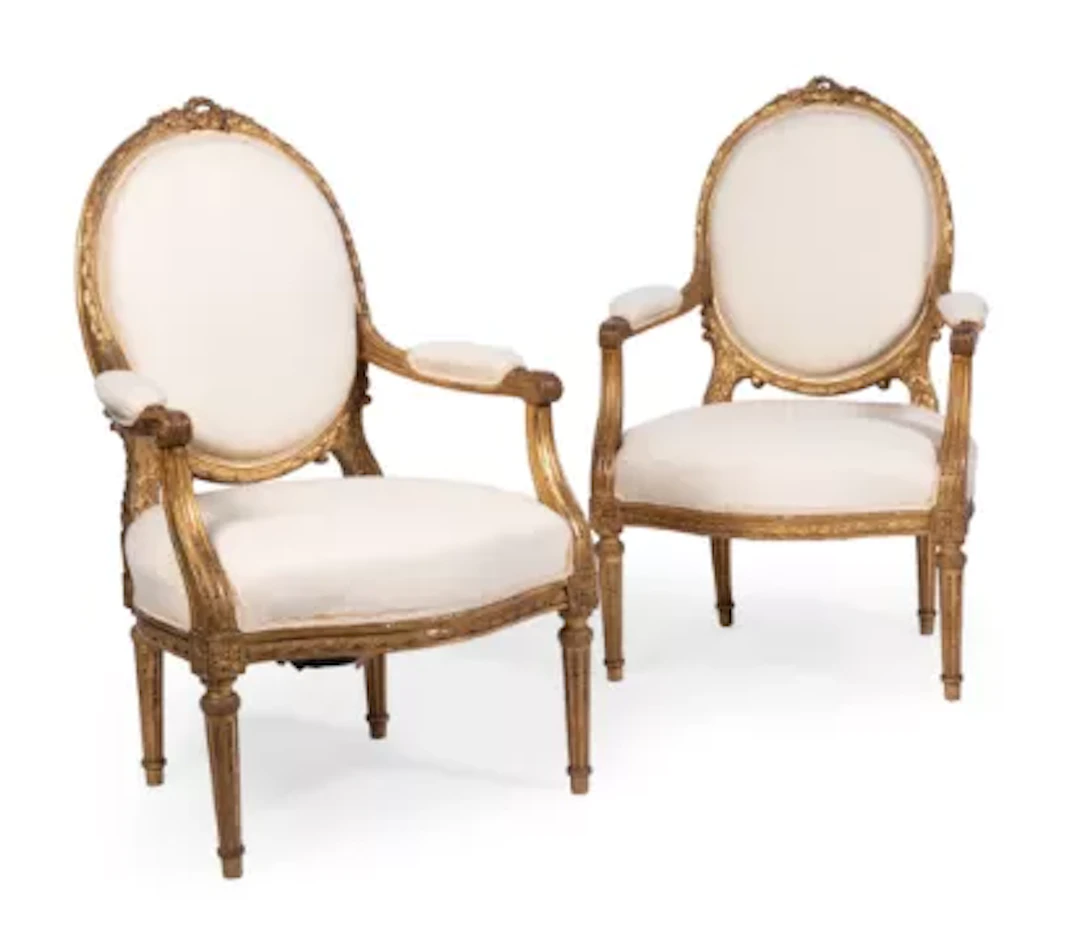A PAIR OF CARVED WOOD AND GILT GESSO AND CREAM UPHOLSTERED OPEN ARMCHAIRS