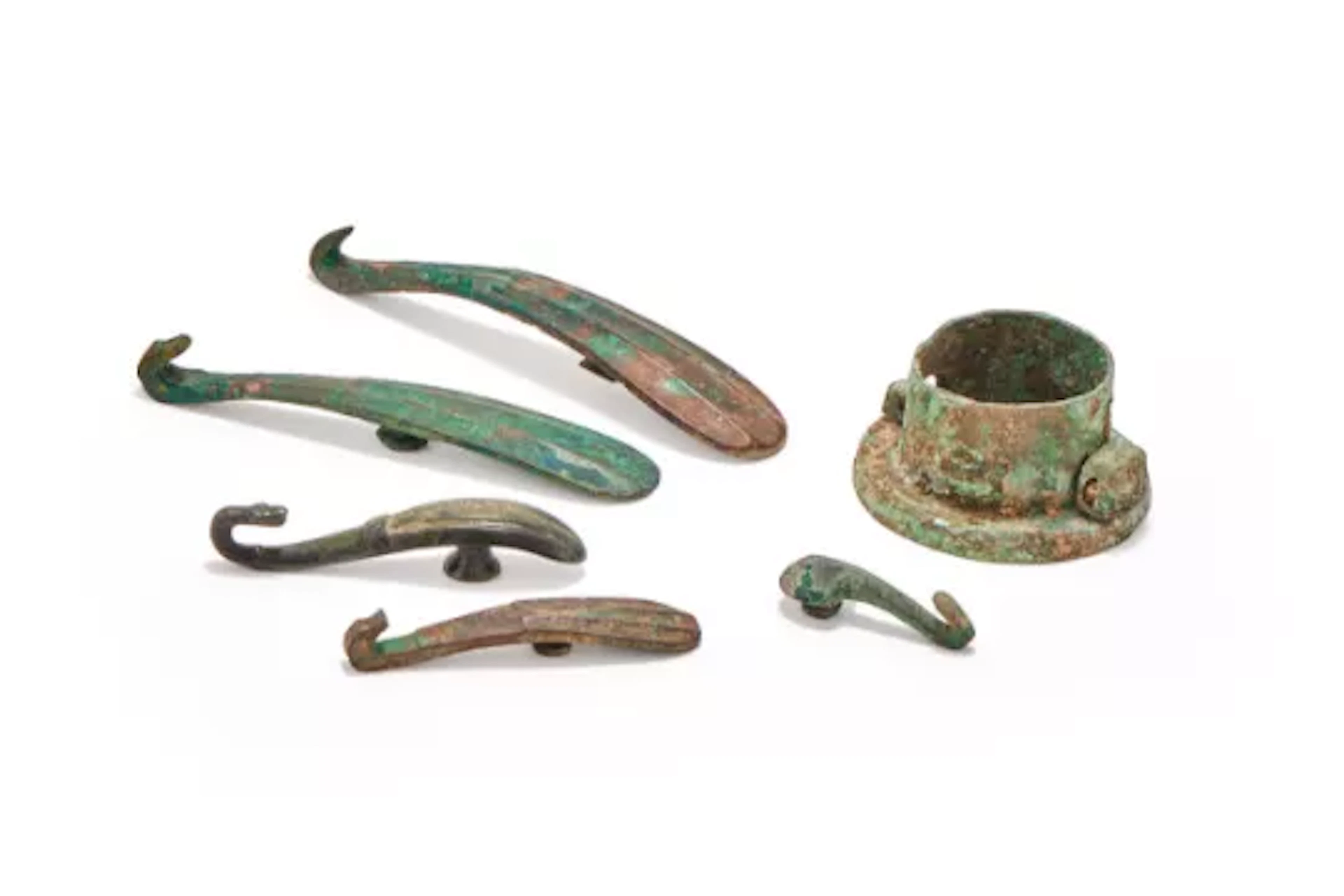A group of five Chinese bronze belt hooks and a chariot fitting, Warring