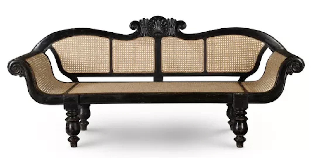 ‡ A CEYLONESE EBONISED HARDWOOD AND CANED SOFA, EARLY 20TH CENTURY
