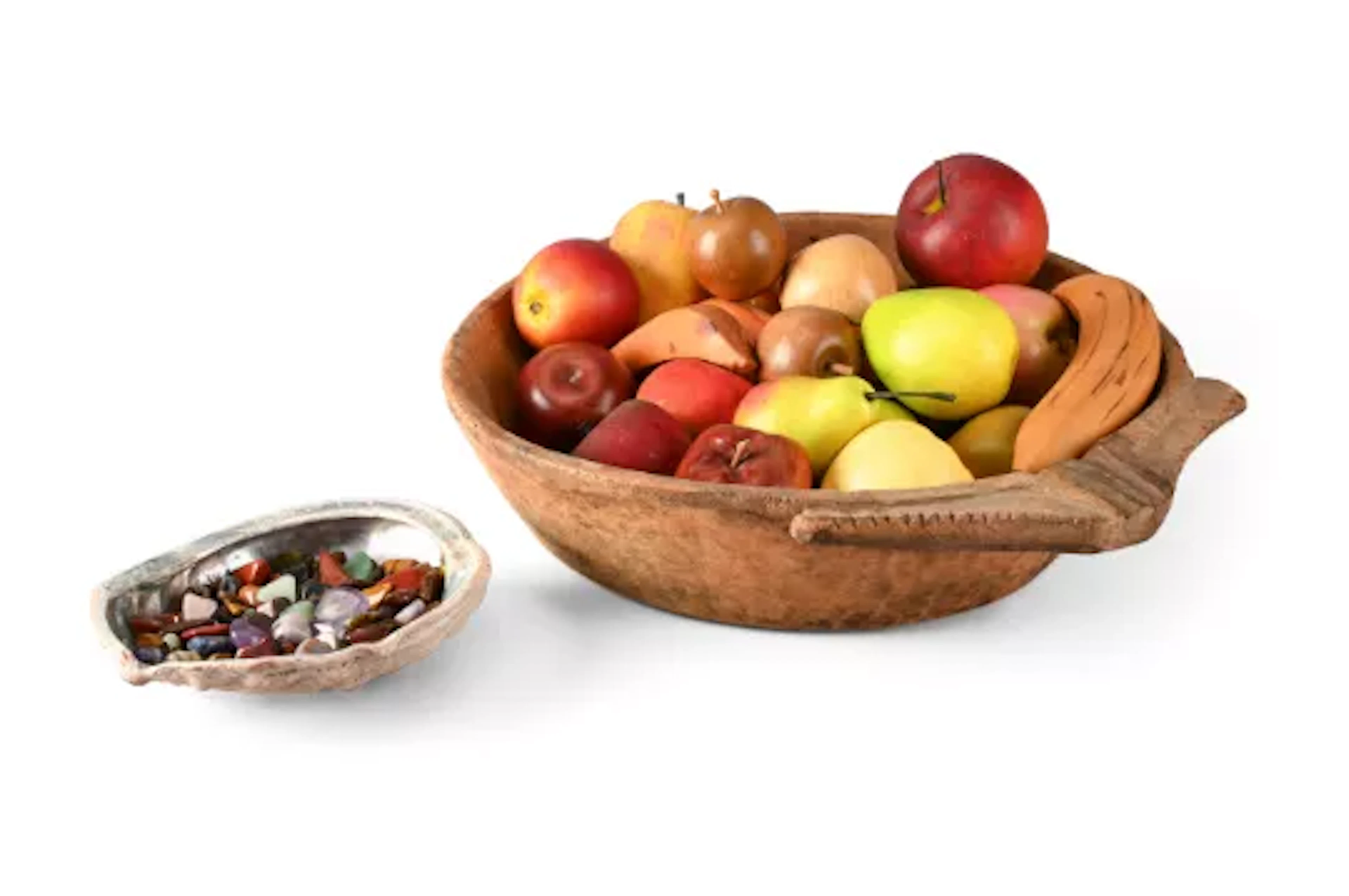A TRIBAL WOODEN BOWL CONTAINING REALISTIC FRUIT, WITH A SEASHELL