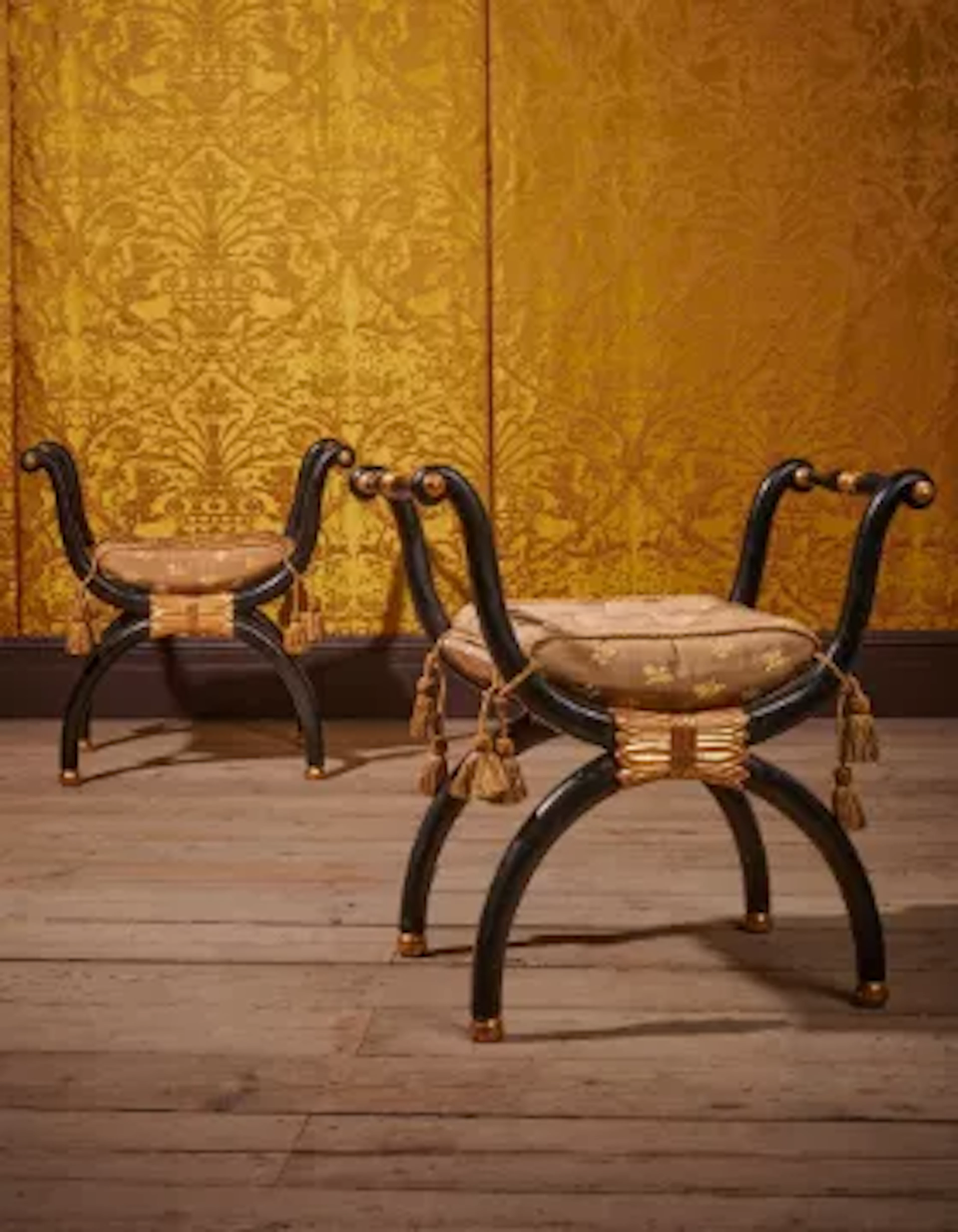 A PAIR OF REGENCY EBONISED AND PARCEL GILT X-FRAME WINDOW SEATS, CIRCA 1815