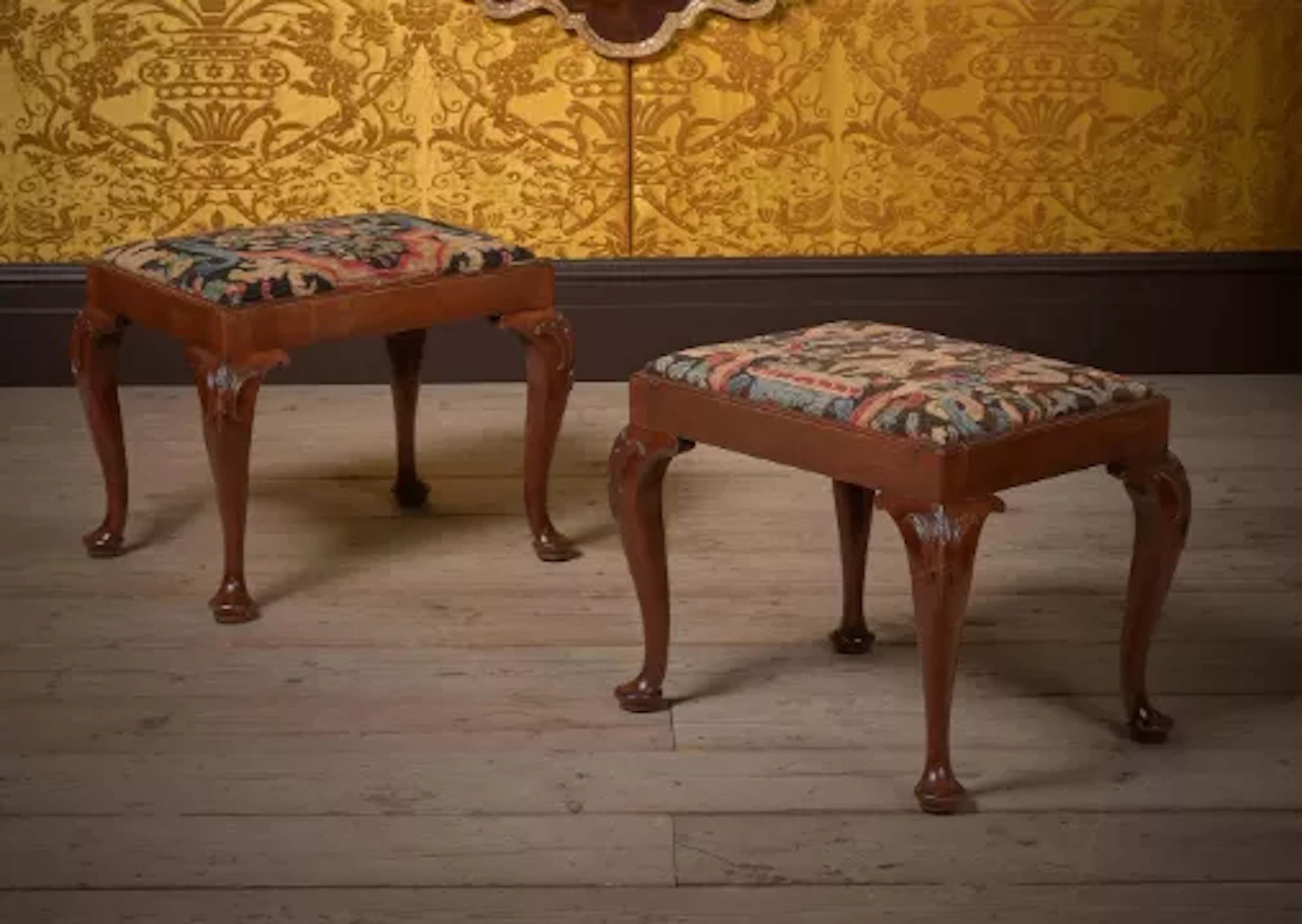 A PAIR OF GEORGE II CARVED MAHOGANY AND NEEDLEWORK UPHOLSTERED STOOLS
