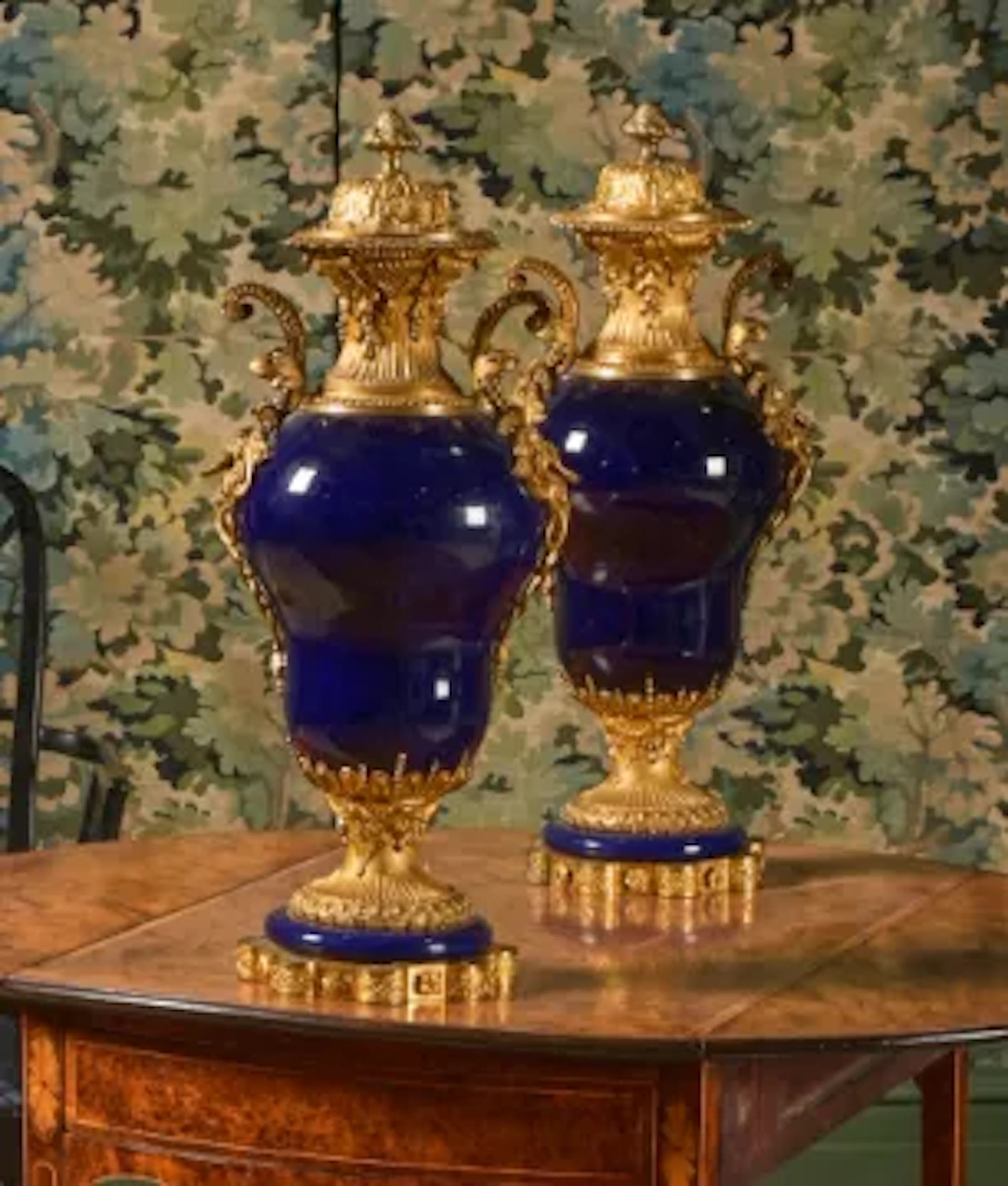A PAIR OF FRENCH GILT METAL MOUNTED DEEP BLUE GLAZED PORCELAIN URNS