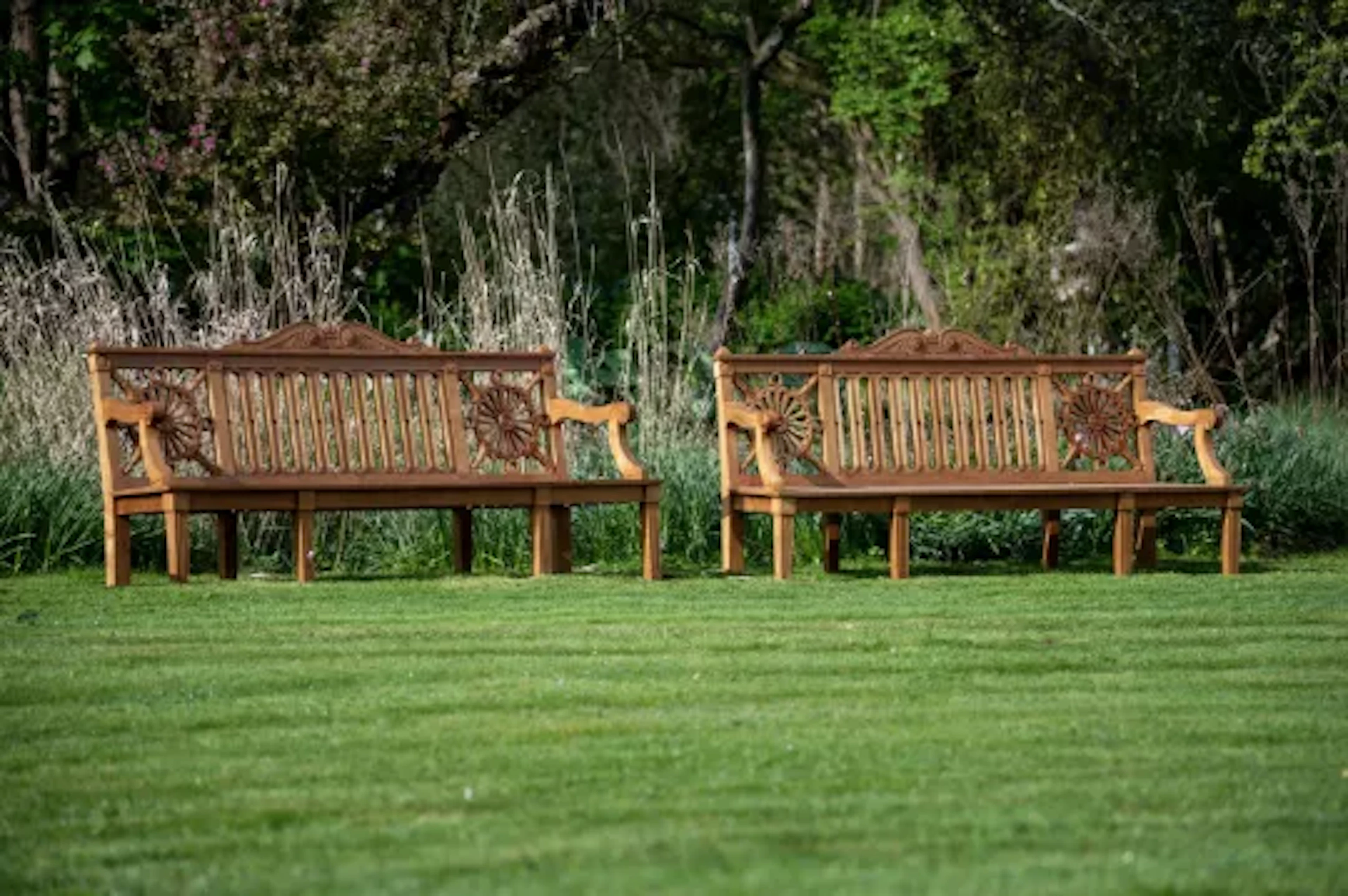 A PAIR OF CARVED TEAK 'HAREWOOD' GARDEN BENCHES, CONTEMPORARY