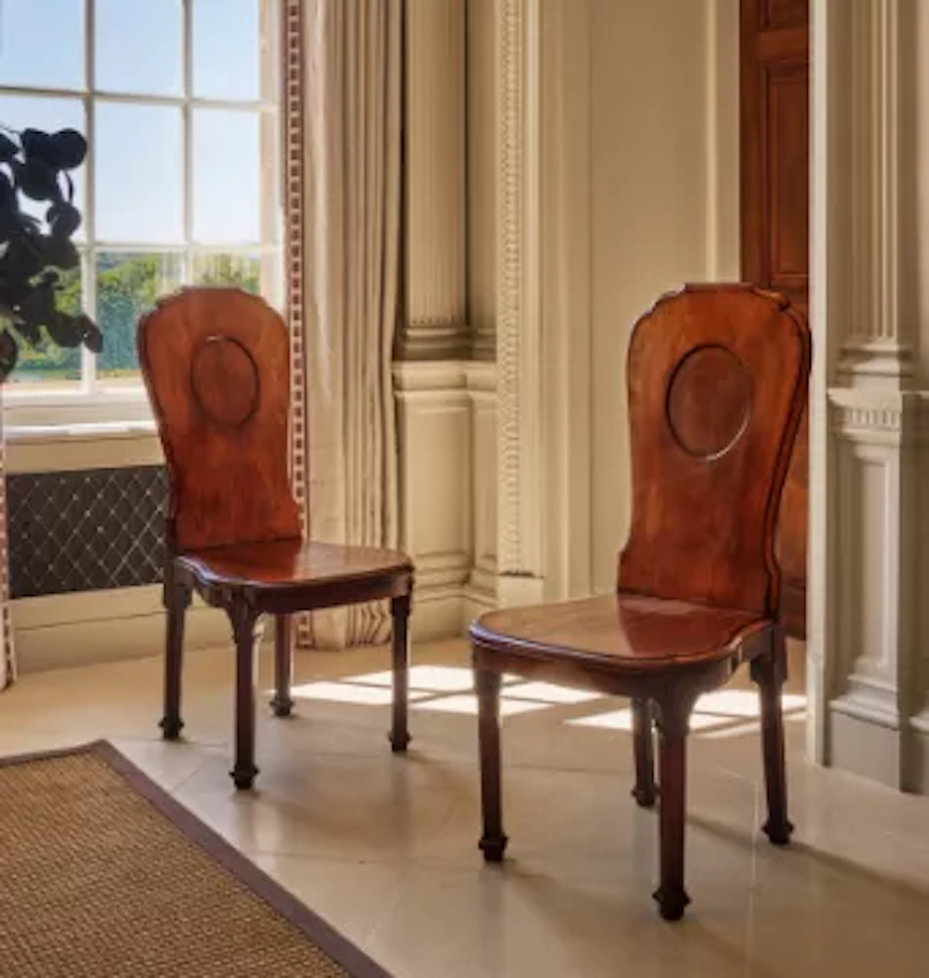 A FINE PAIR OF GEORGE III MAHOGANY HALL CHAIRS, IN THE MANNER OF THOMAS
