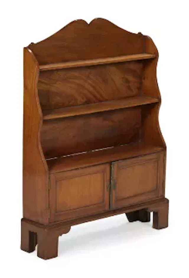 A SMALL MAHOGANY 'WATERFALL' CUPBOARD BOOKCASE, IN REGENCY STYLE