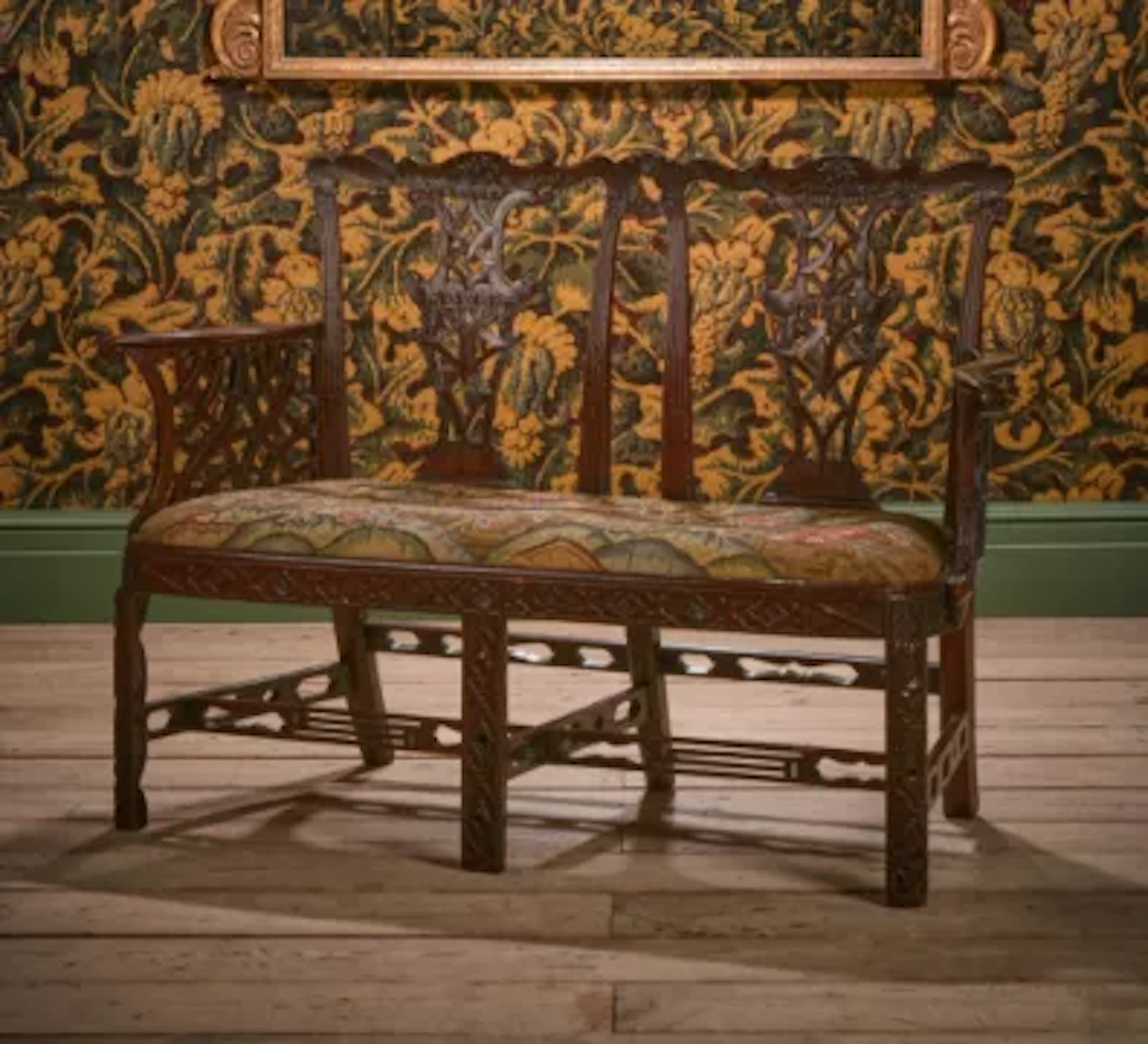 A GEORGE III CARVED MAHOGANY CHAIR BACK SETTEE, IN THE MANNER OF THOMAS
