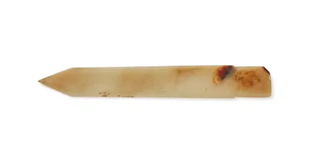 A Chinese celadon and russet jade dagger axe, ge, Late Shang Dynasty