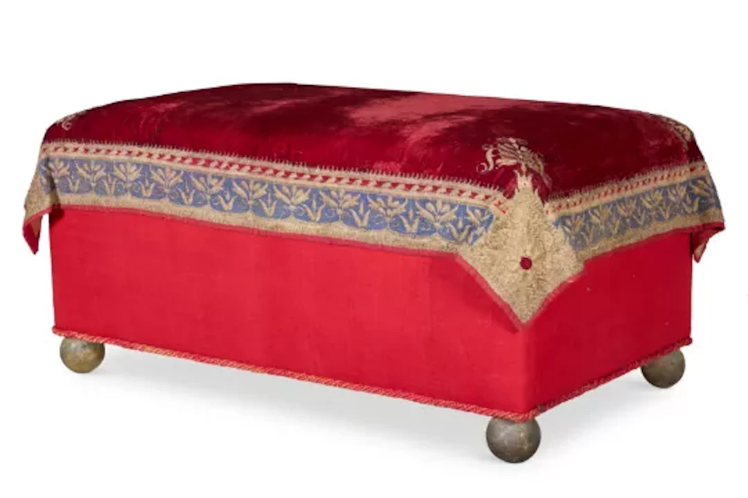 A GOLD THREAD EMBROIDERED RED VELVET COVERED OTTOMAN