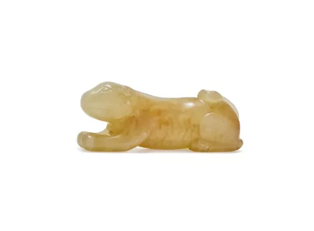 A Chinese celadon and brown jade model of a dog, Late Ming or Qing dynasty