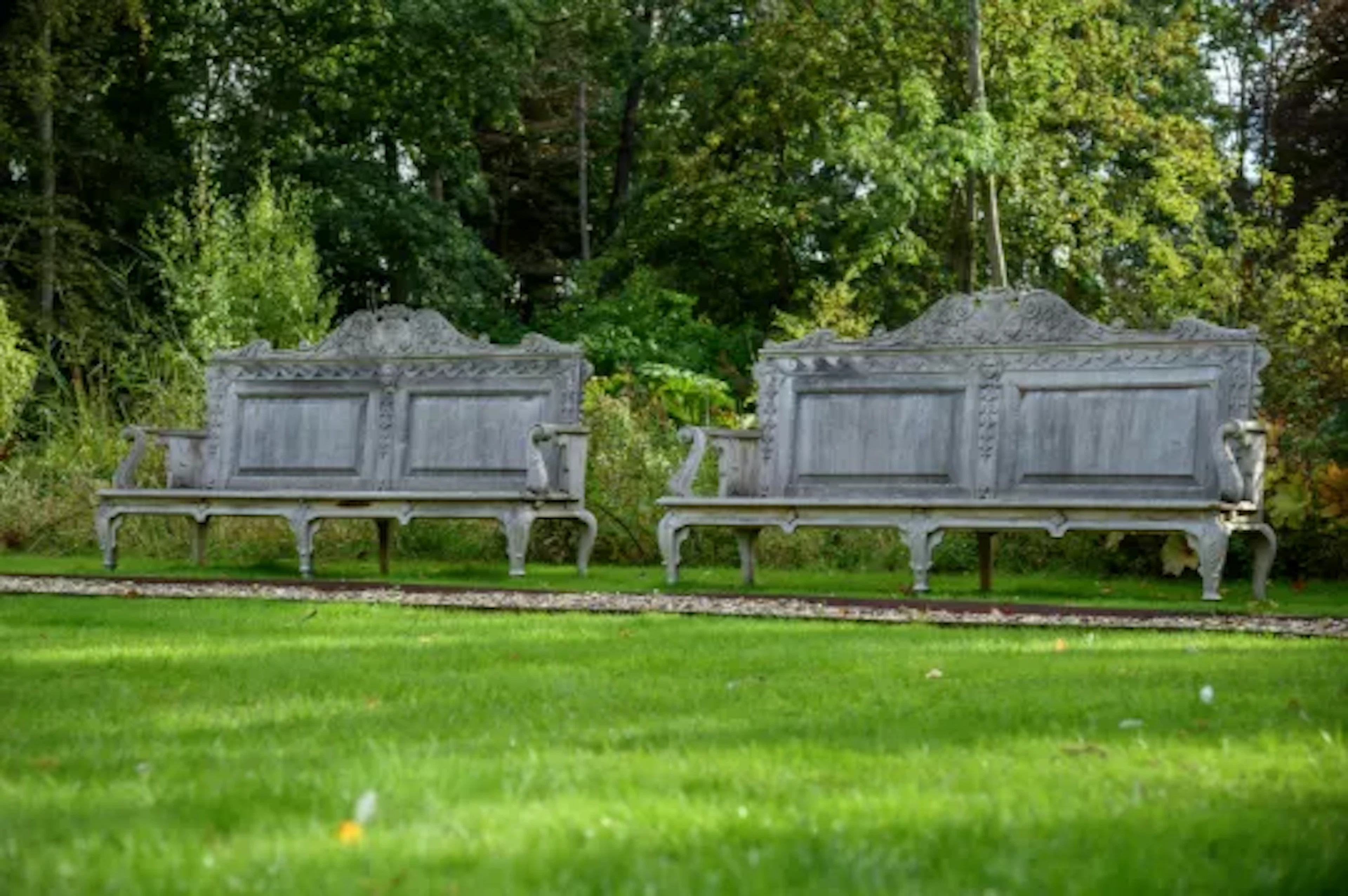 A LARGE PAIR OF CARVED TEAK GARDEN BENCHES, IN GEORGE II STYLE, CONTEMPORARY