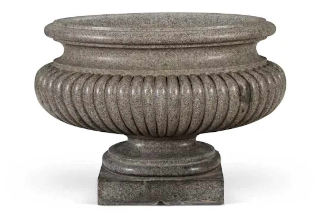 ‡ AFTER THE ANTIQUE - A LARGE ELLIPTICAL CARVED GRANITE CISTERN OR LABRUM