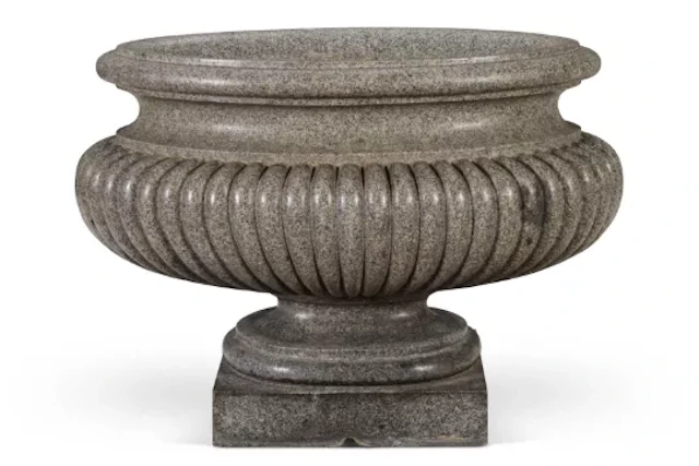 ‡ AFTER THE ANTIQUE - A LARGE ELLIPTICAL CARVED GRANITE CISTERN OR LABRUM