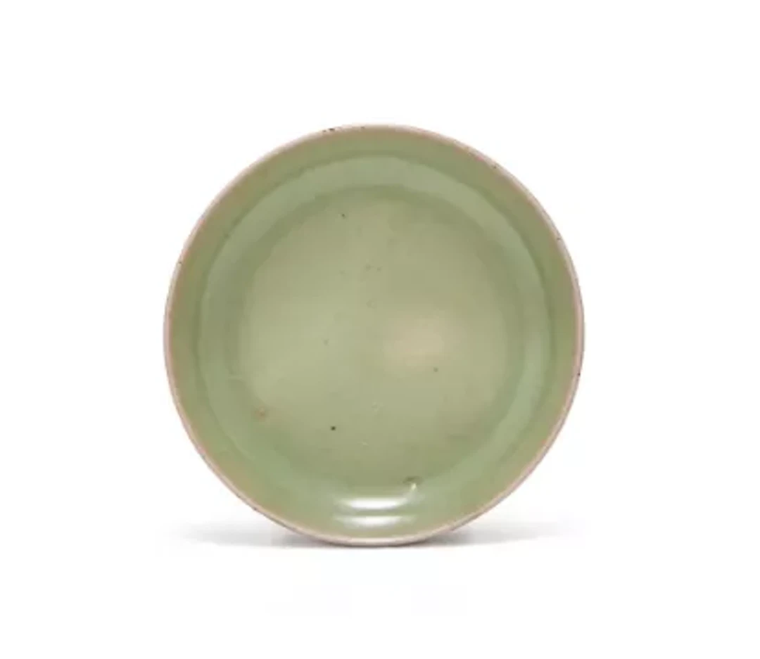 A Chinese small celadon dish, with even slightly crackled green glaze