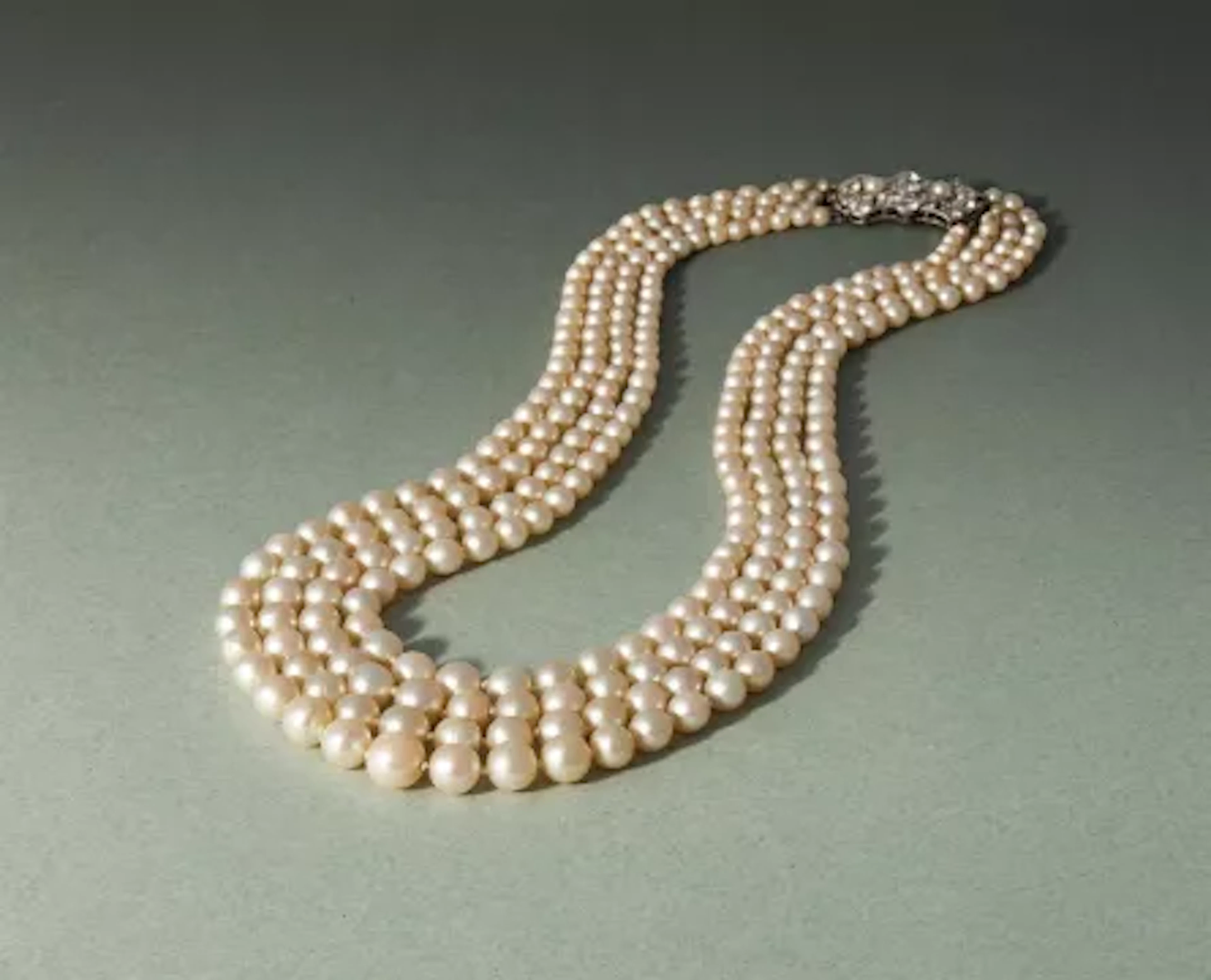 AN EARLY 20TH CENTURY FOUR ROW NATURAL PEARL AND DIAMOND NECKLACE
