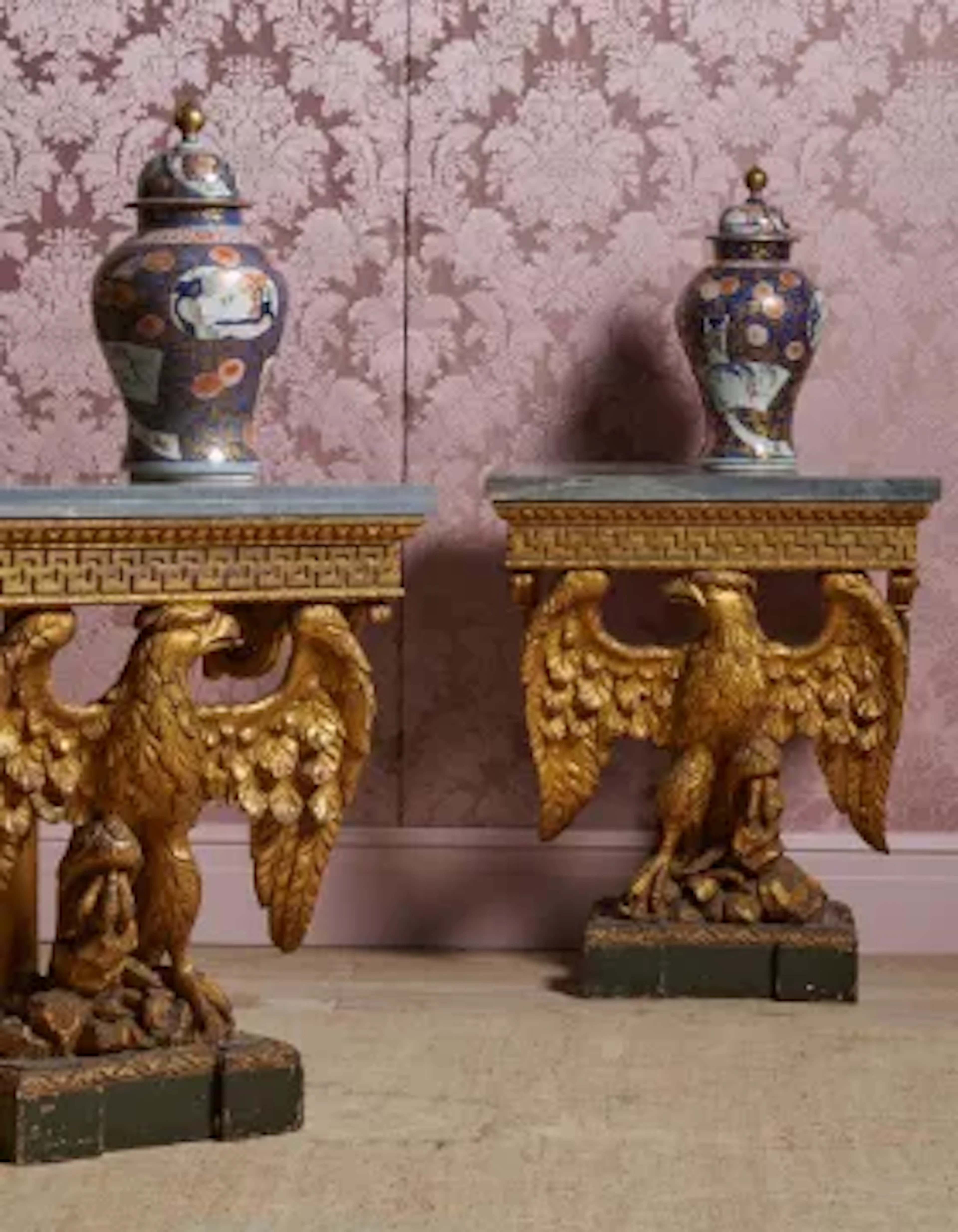 A PAIR OF CARVED GILTWOOD AND MARBLE TOPPED EAGLE CONSOLE TABLES