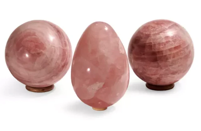 TWO POLISHED ROSE QUARTZ SPHERES AND A POLISHED ROSE QUARTZ EGG