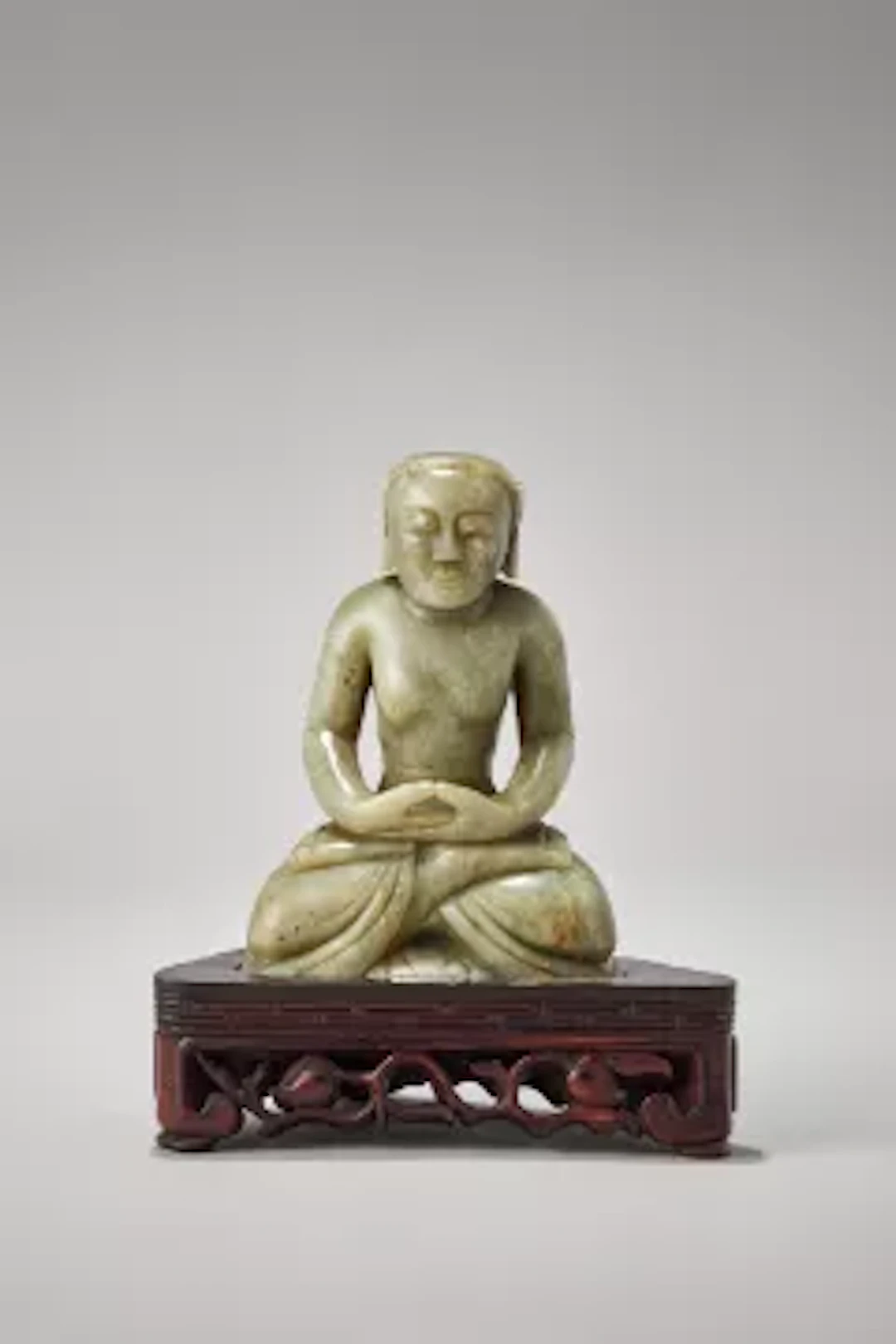 A large Chinese carved celadon jade model of a seated buddha, Yuan/Ming Dynasty
