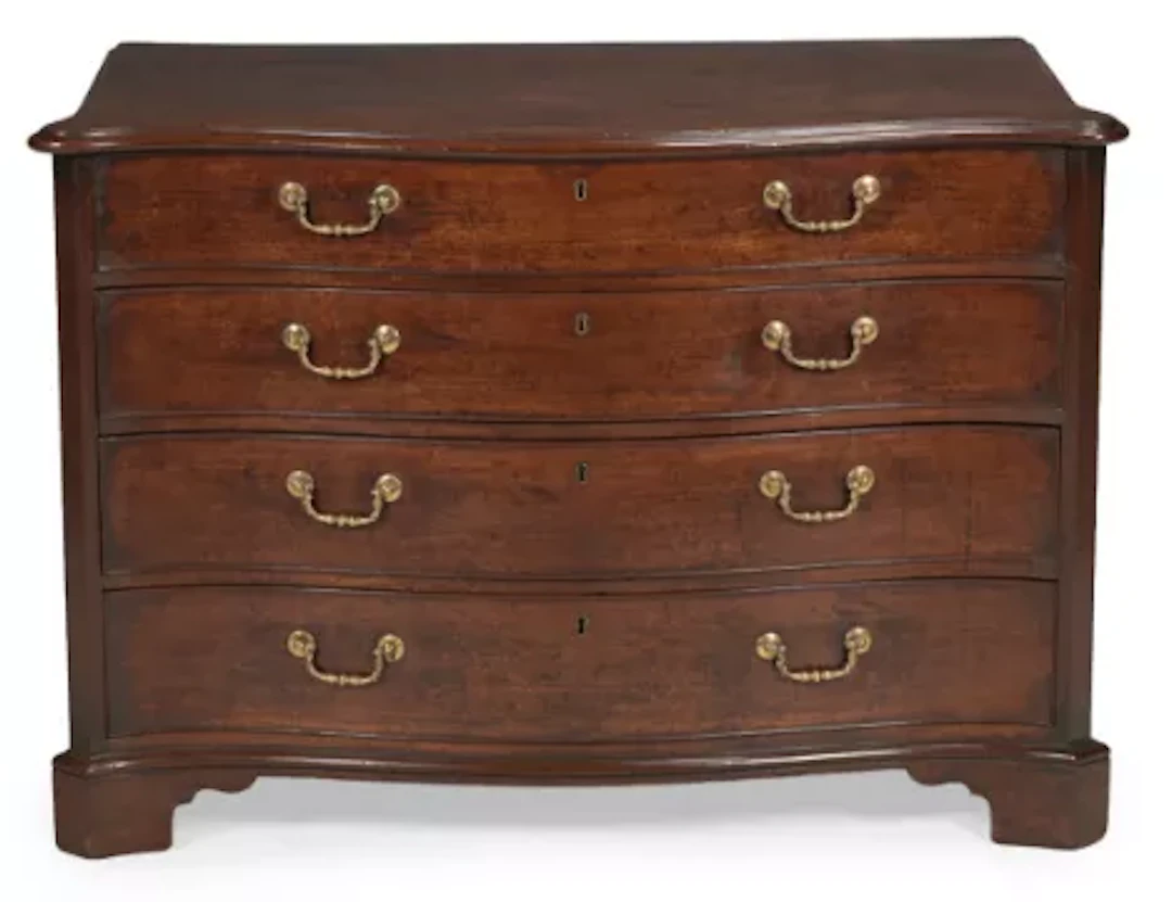 A GEORGE III MAHOGANY SERPENTINE FRONTED COMMODE, IN THE MANNER OF