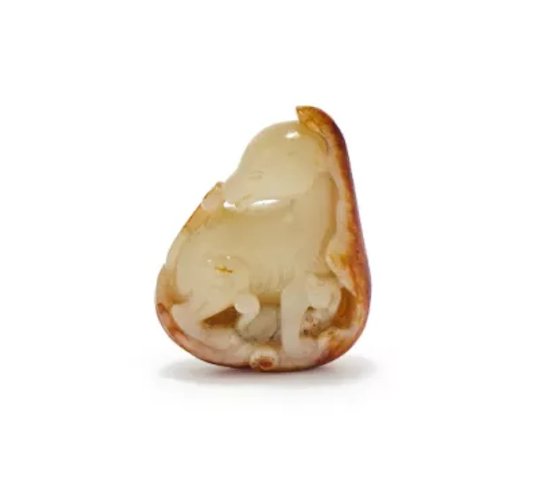 A Chinese carved pale celadon and russet jade 'Hound and cub' pendant