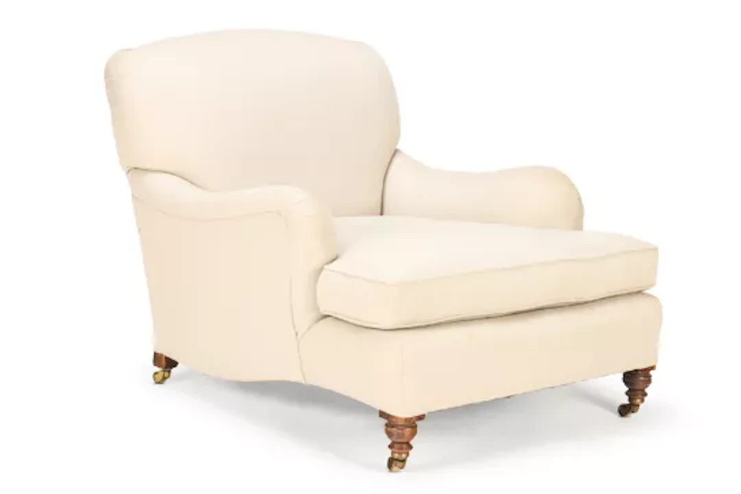 AN EDWARDIAN EASY ARMCHAIR OF LARGE SIZE, BY HOWARD & SONS