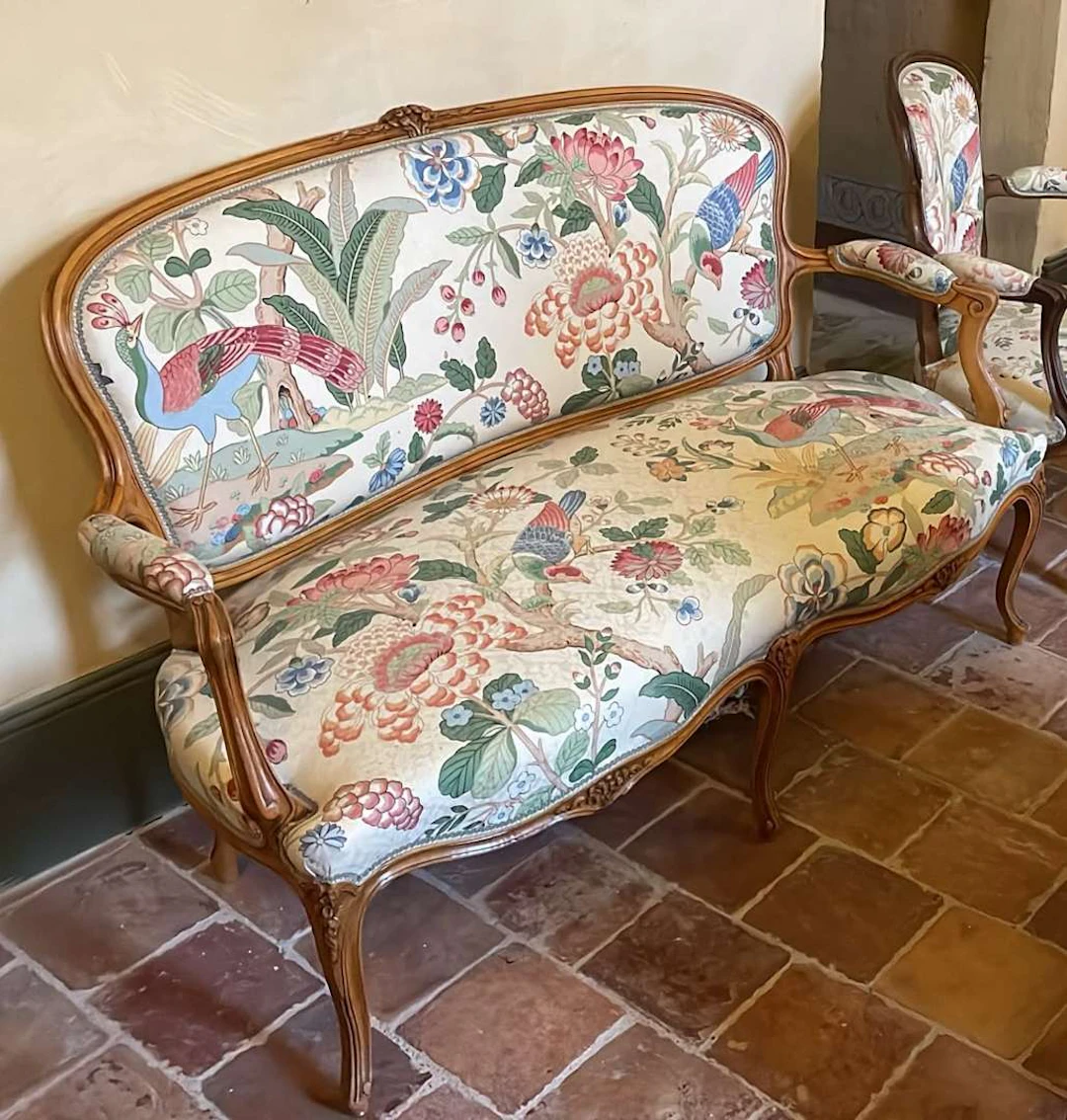 A two-seater sofa and an armchair, carved and moulded wood