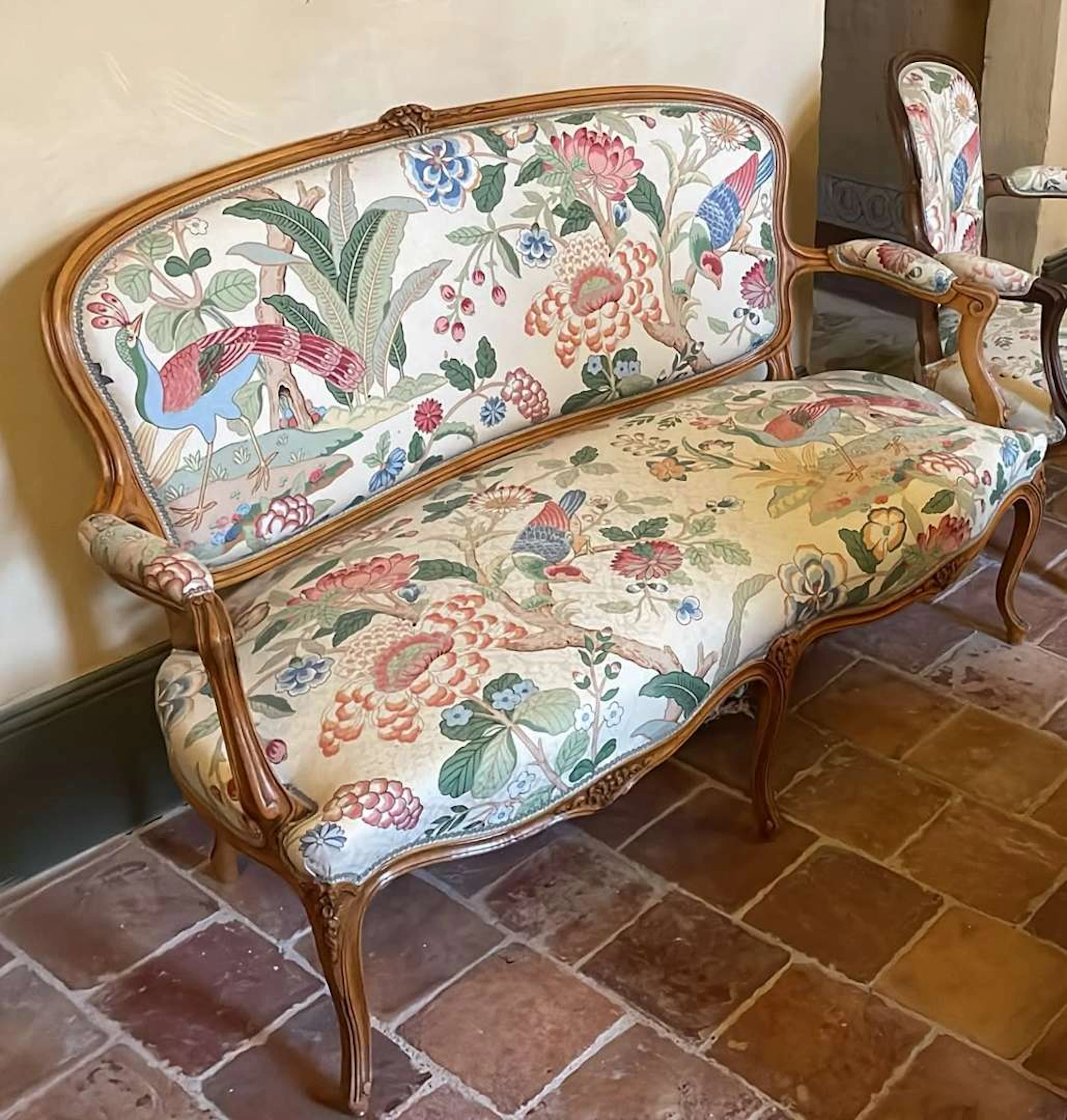 A two-seater sofa and an armchair, carved and moulded wood