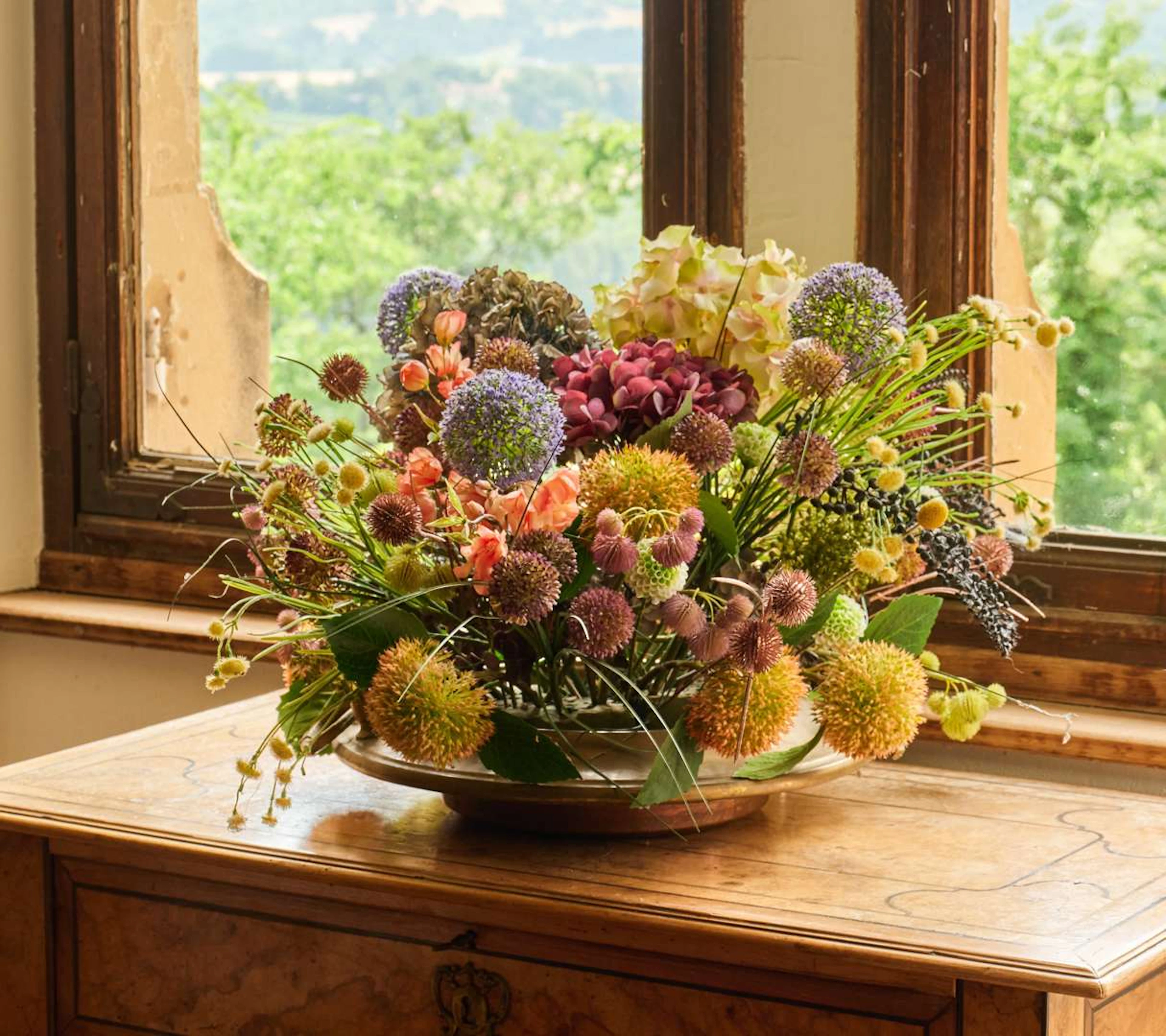 Bowl and floral arrangement, Large circular metal bowl with artificial flowers