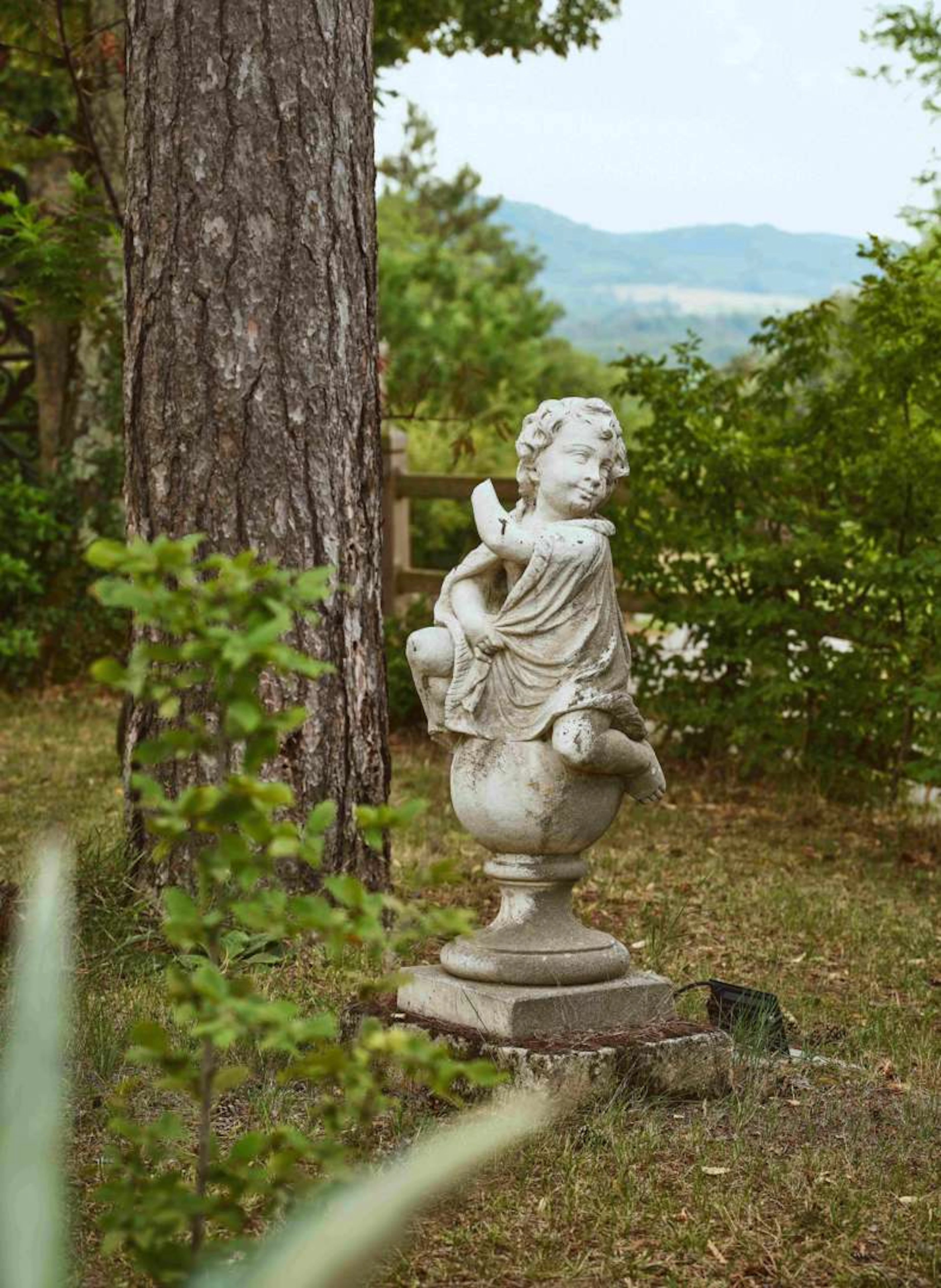Putto on a globe, Sculpture made from imitation reconstituted stone