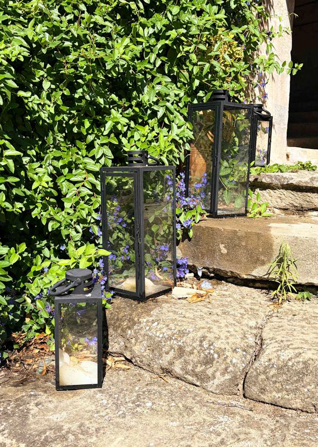 Three garden lanterns, Metal and glass garden lanterns, fitted with