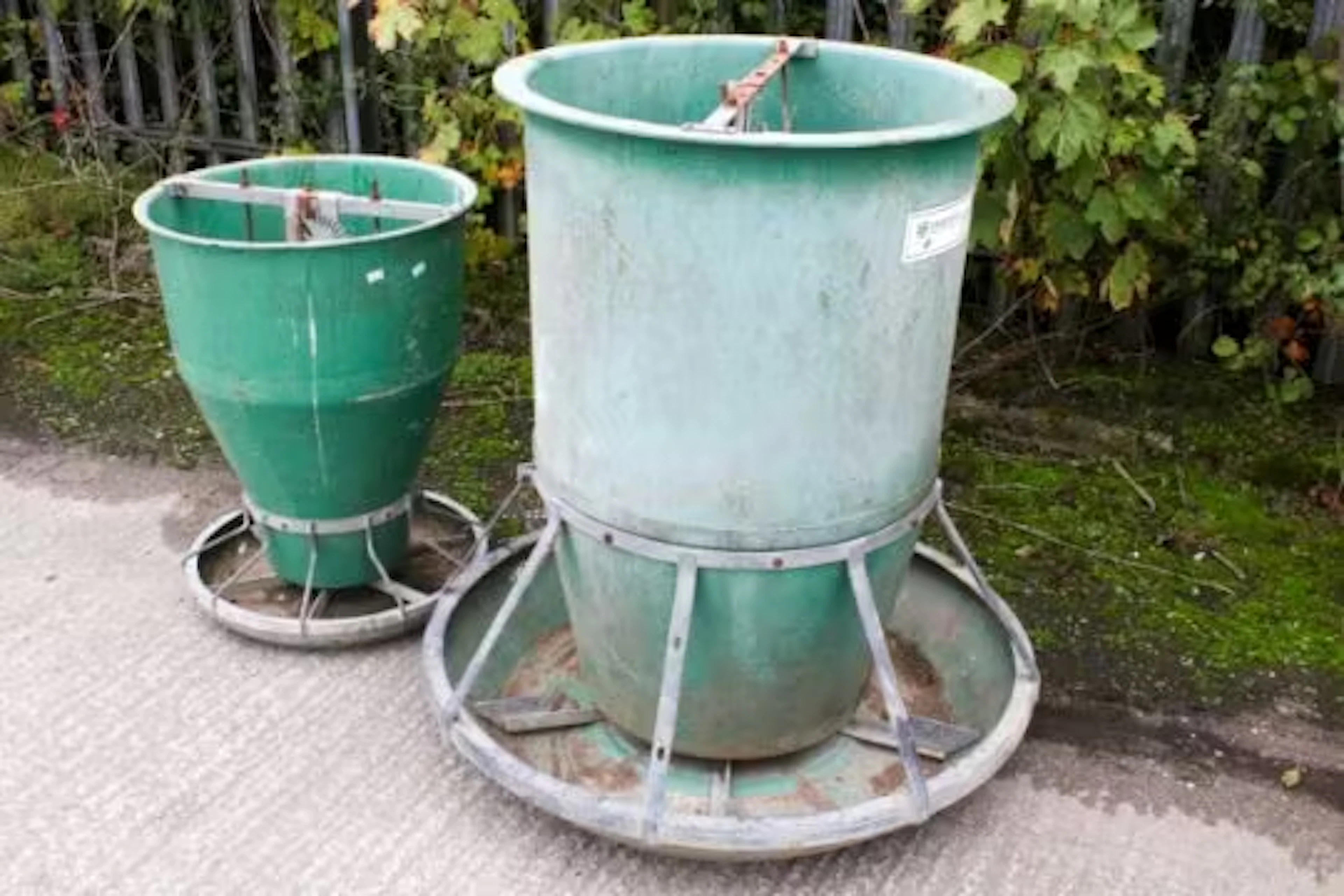 An Osborne Big Wheel pig feeder and a similar unbranded example.
