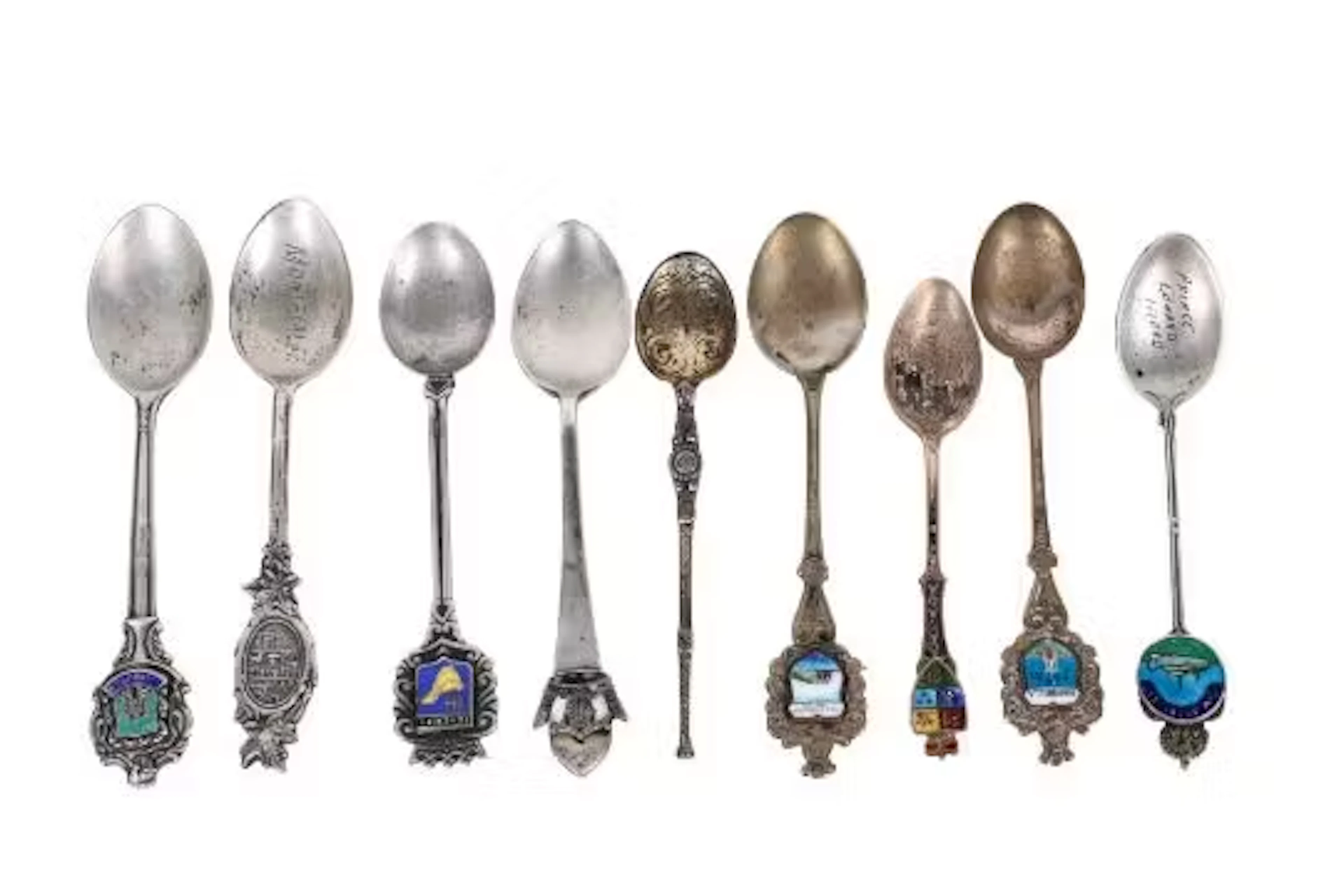 A collection of silver and white metal teaspoons.