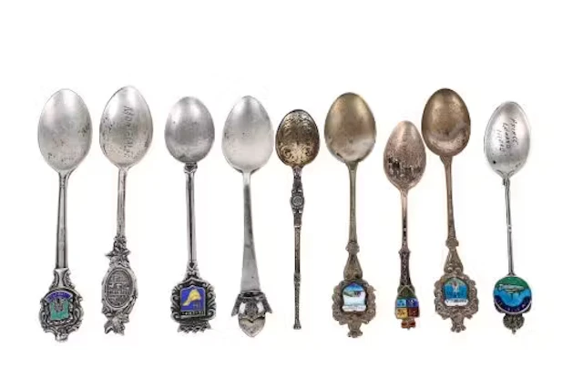 A collection of silver and white metal teaspoons.