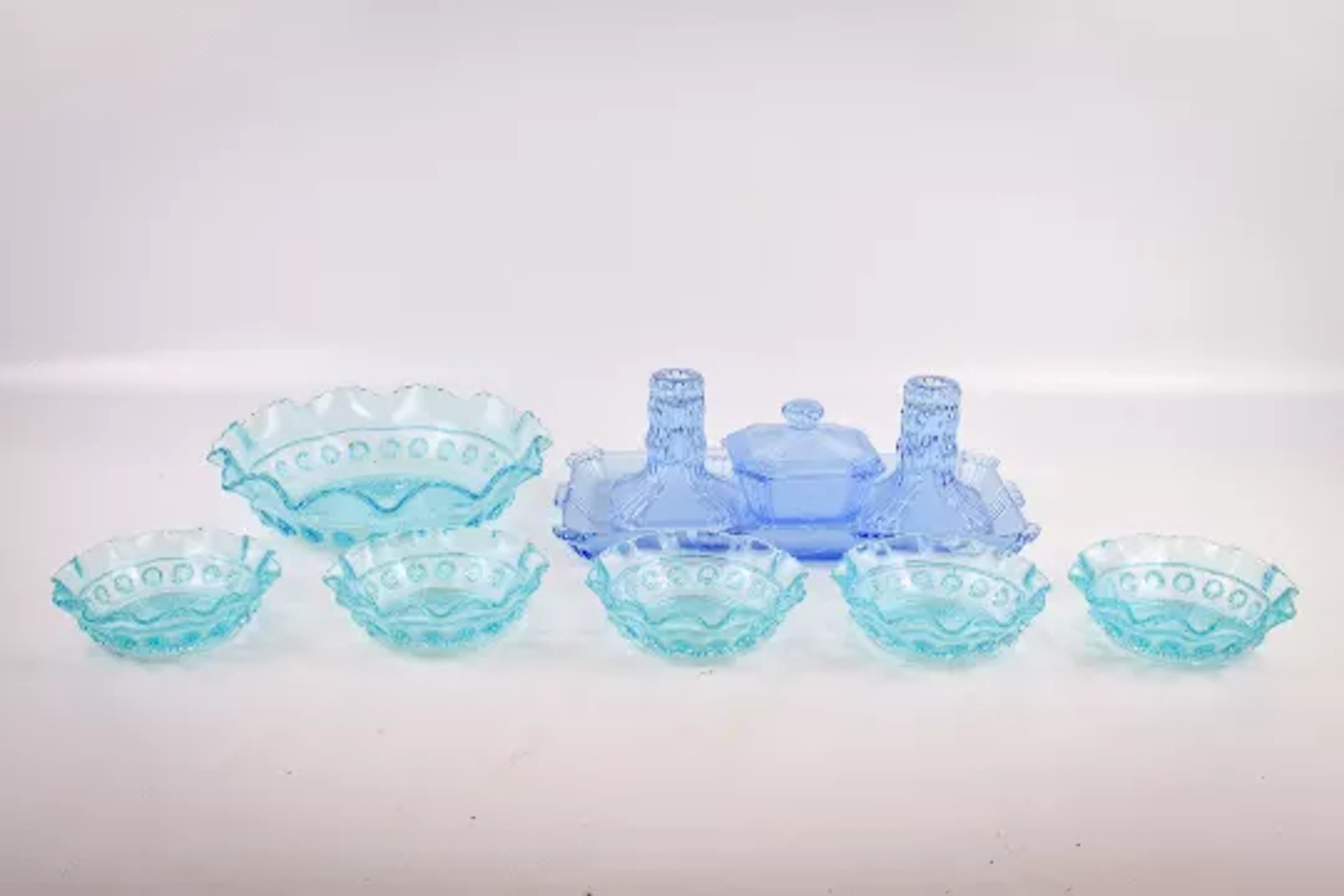 A collection of coloured pressed glassware.