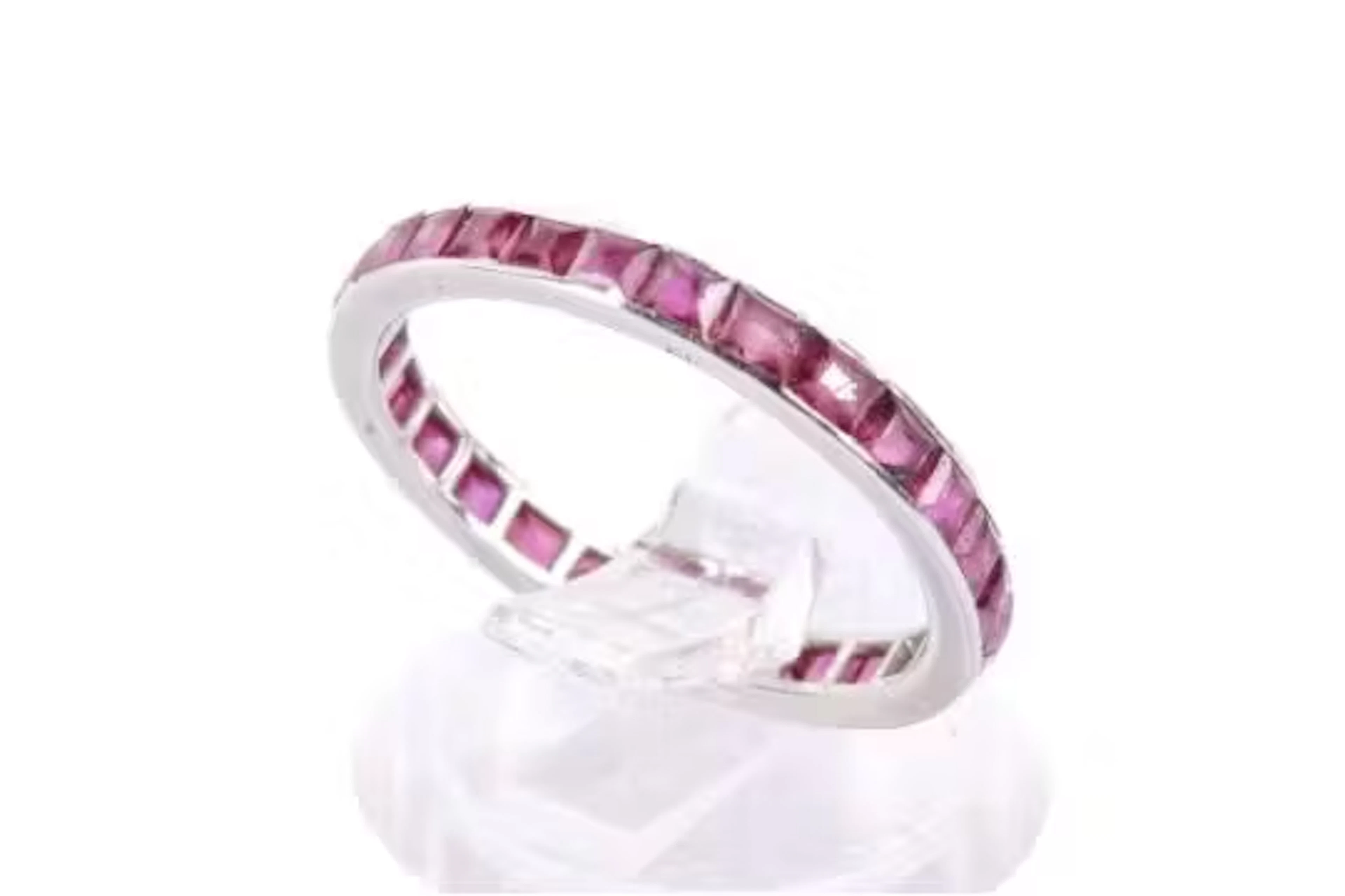 A full eternity ring set with square faceted rubies. Metal not marked