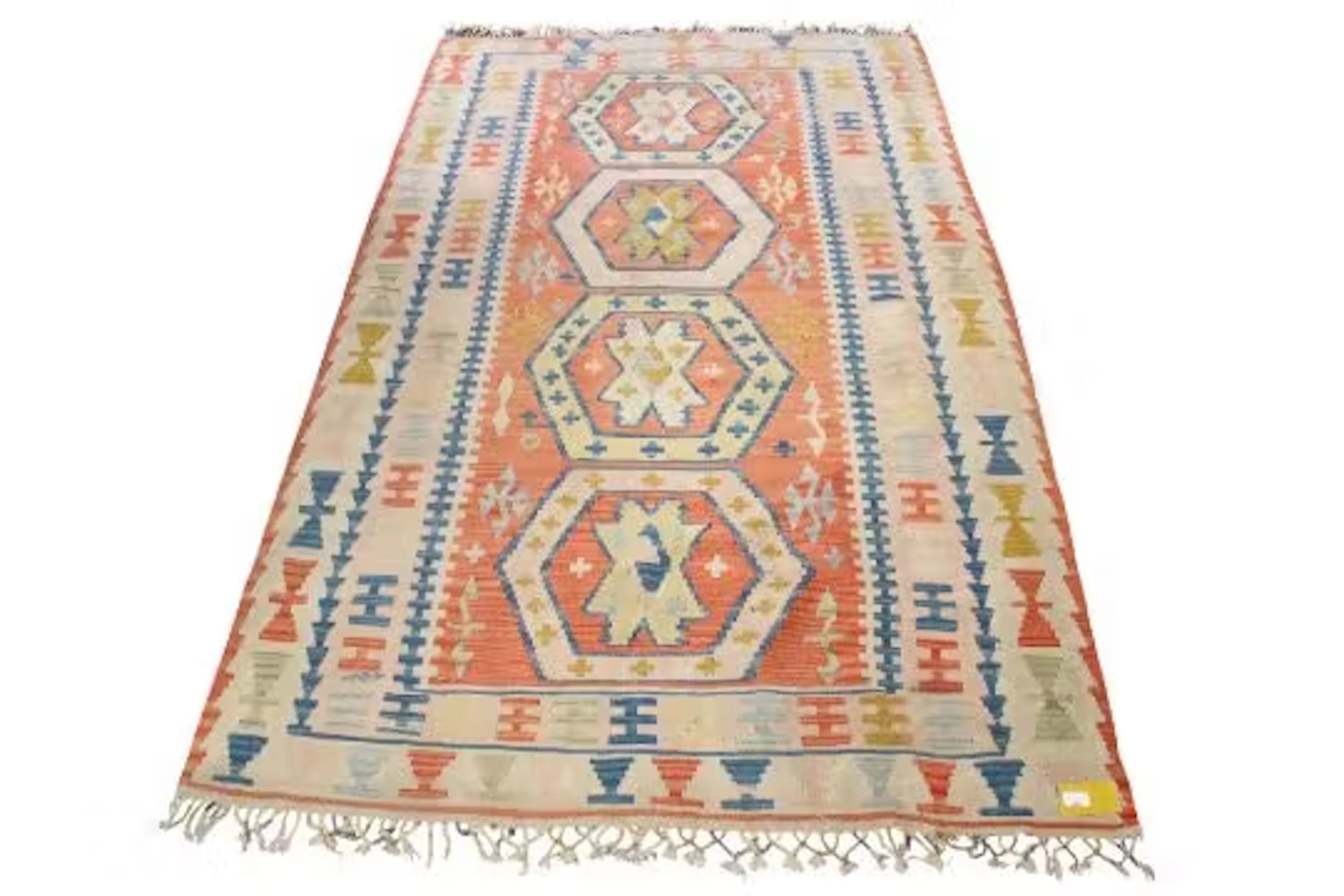 A Kilim style wool rug on an orange ground. Having stylized geometric borders.