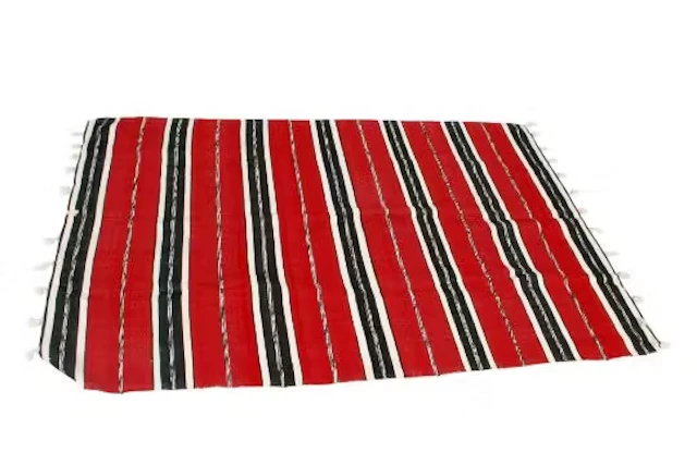 A Moroccan wool rug with red and black stripes.