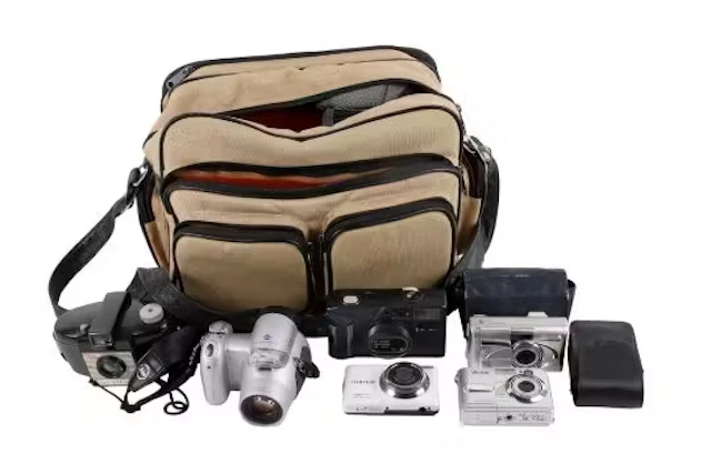 A group of assorted vintage cameras in a bag. Including an Olympus