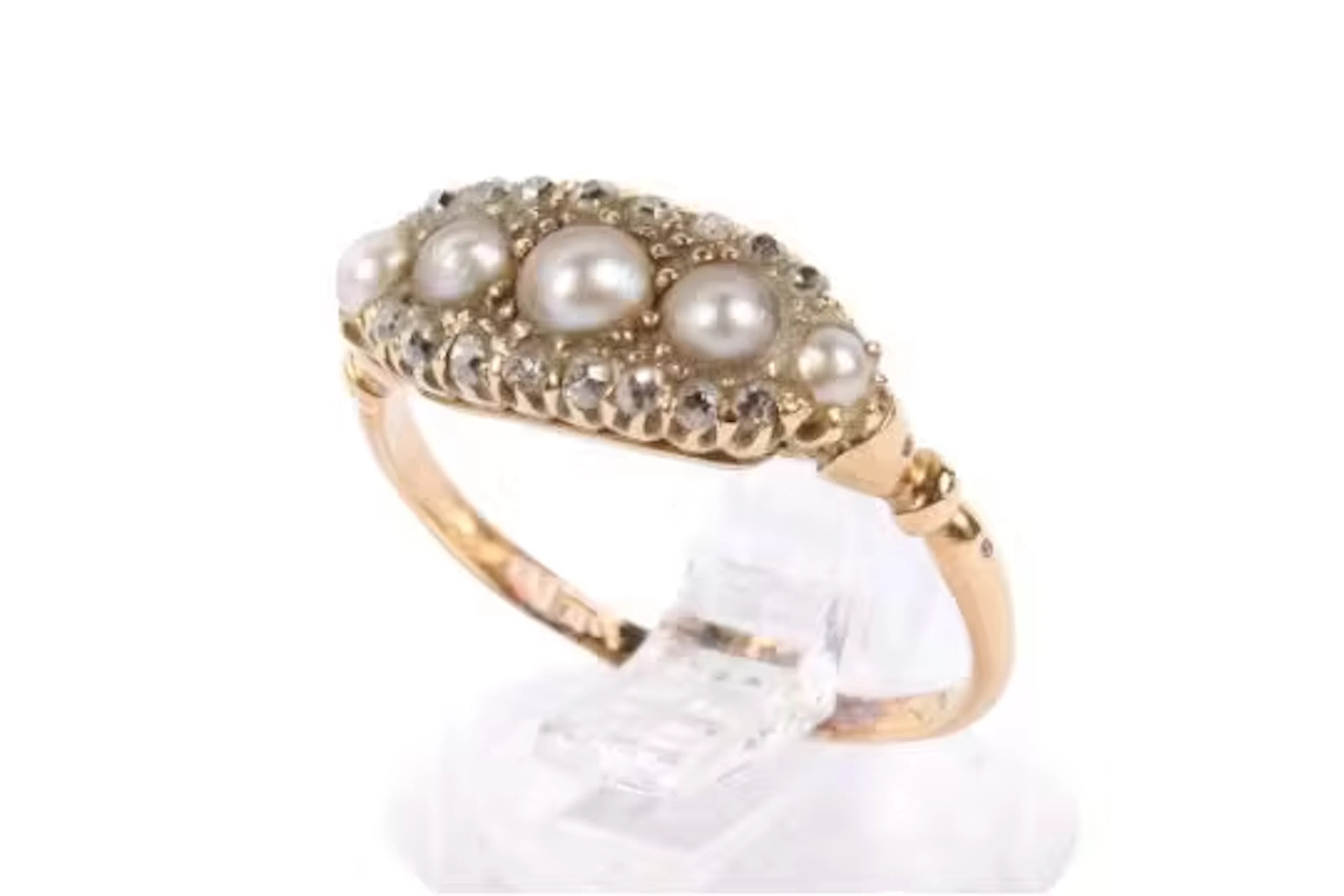 An antique dress ring. Set with five graduated half pearls with a