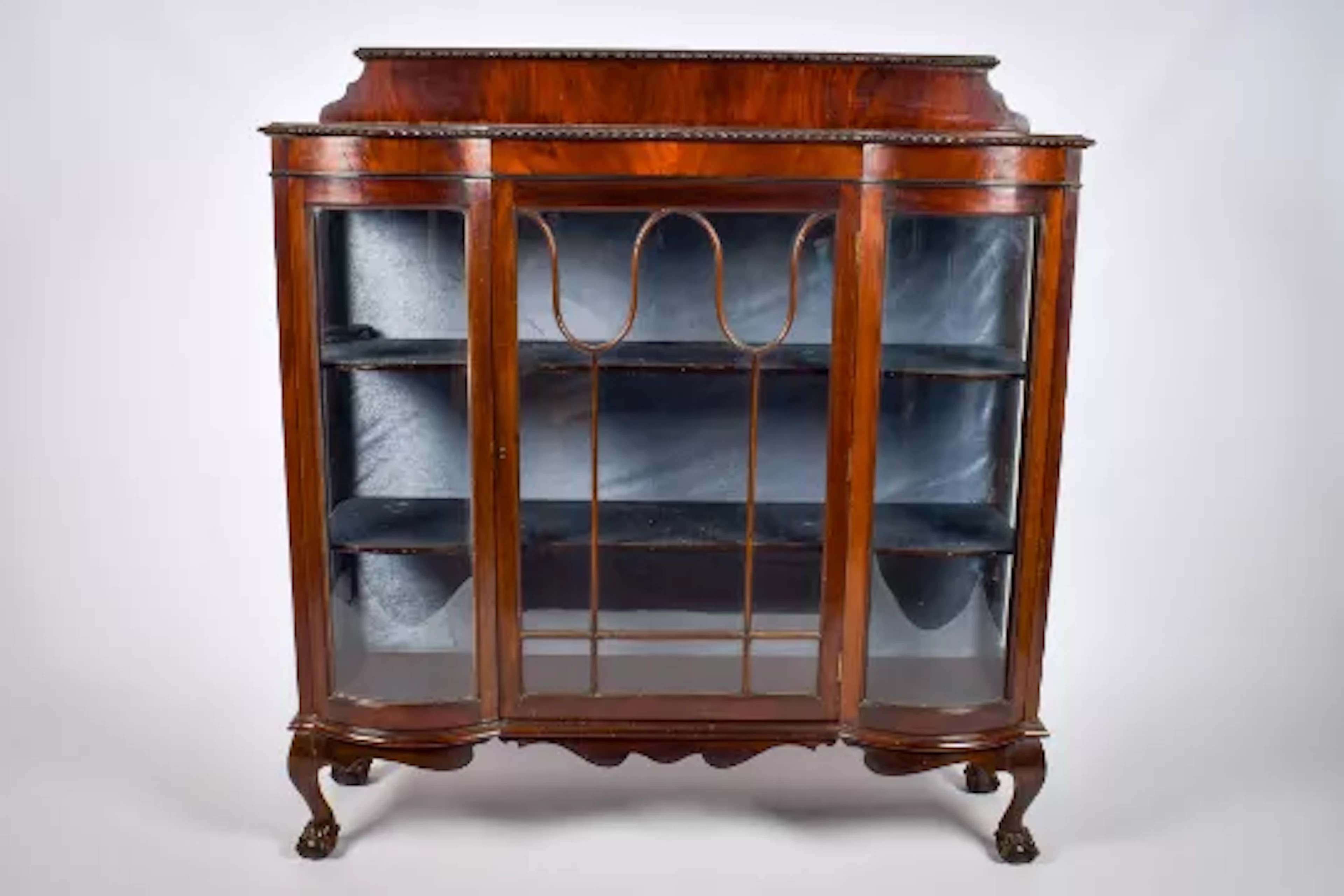 An Edwardian mahogany glazed serpentine display cabinet.