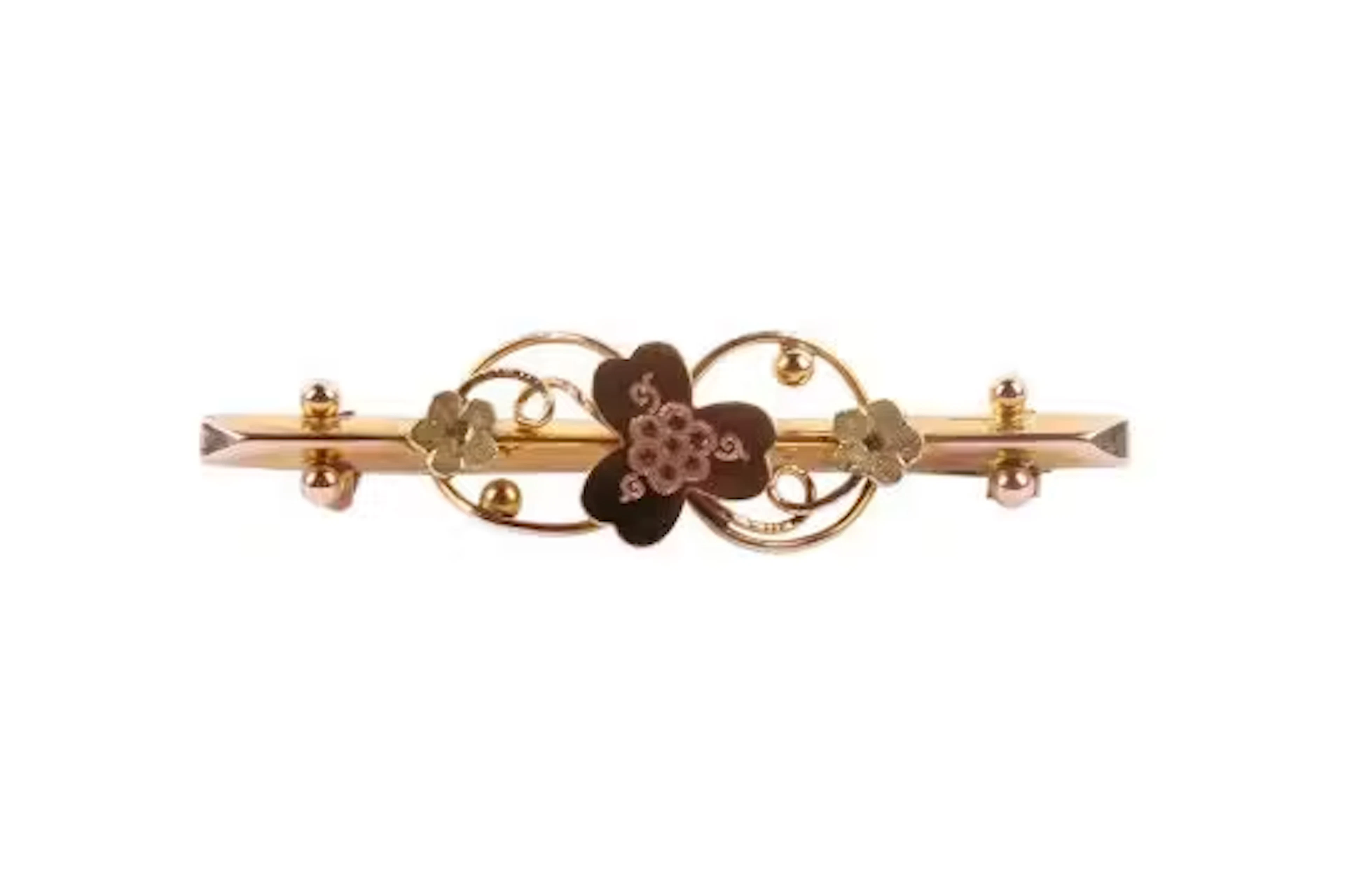 A tri-colour 9ct gold bar brooch. With flower decoration, hallmarked
