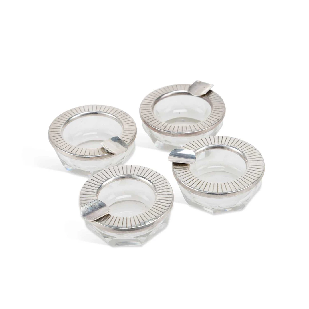 A SET OF FOUR ARGENTINEAN MODERNIST SILVER-MOUNTED CUT-GLASS ASHTRAYS