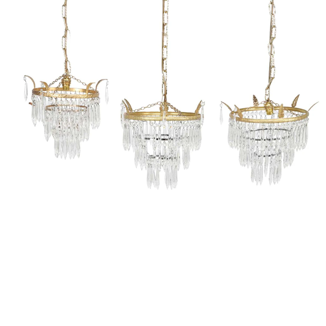A PAIR OF GILT METAL AND GLASS WATERFALL CHANDELIERS AND A SIMILAR SINGLE