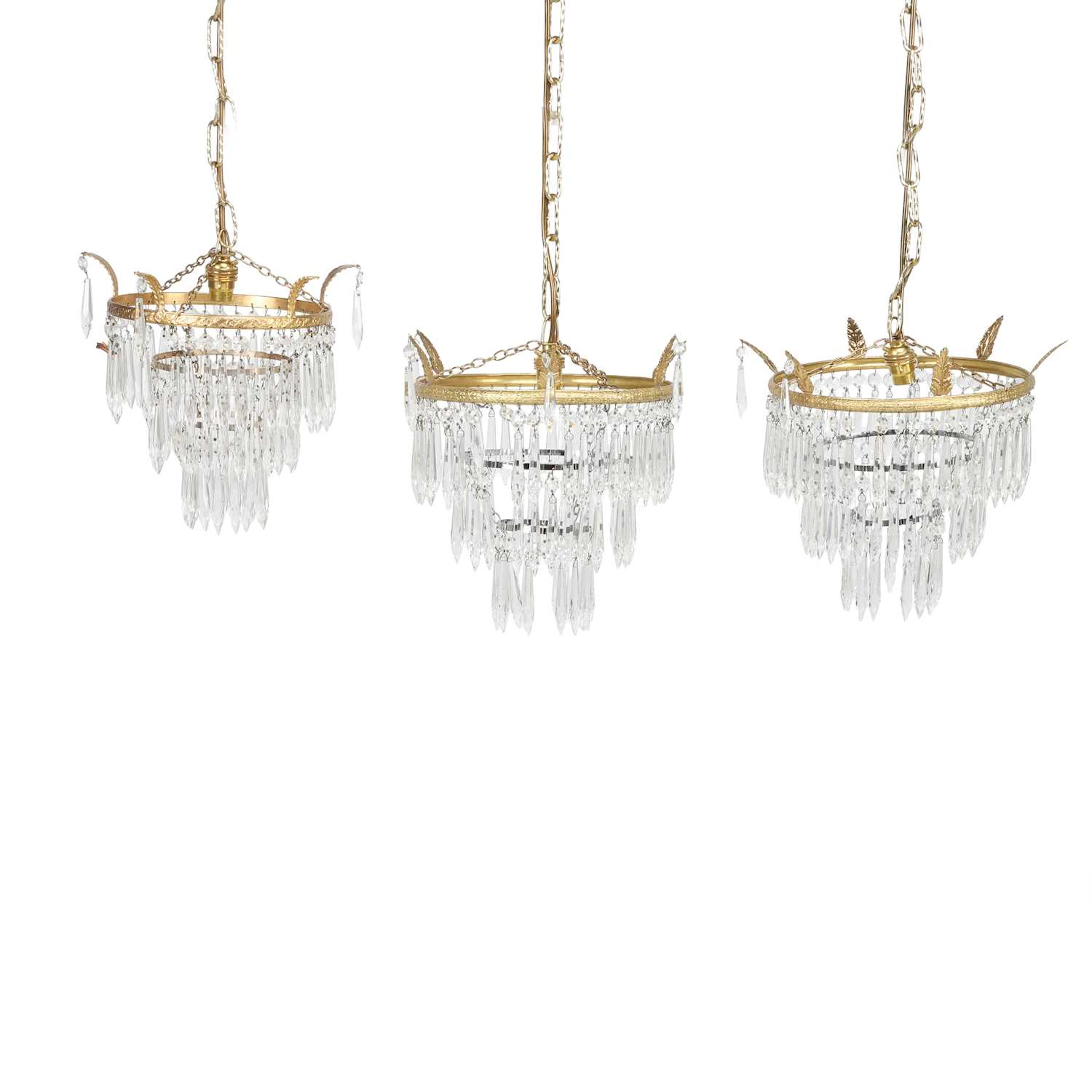 A PAIR OF GILT METAL AND GLASS WATERFALL CHANDELIERS AND A SIMILAR SINGLE
