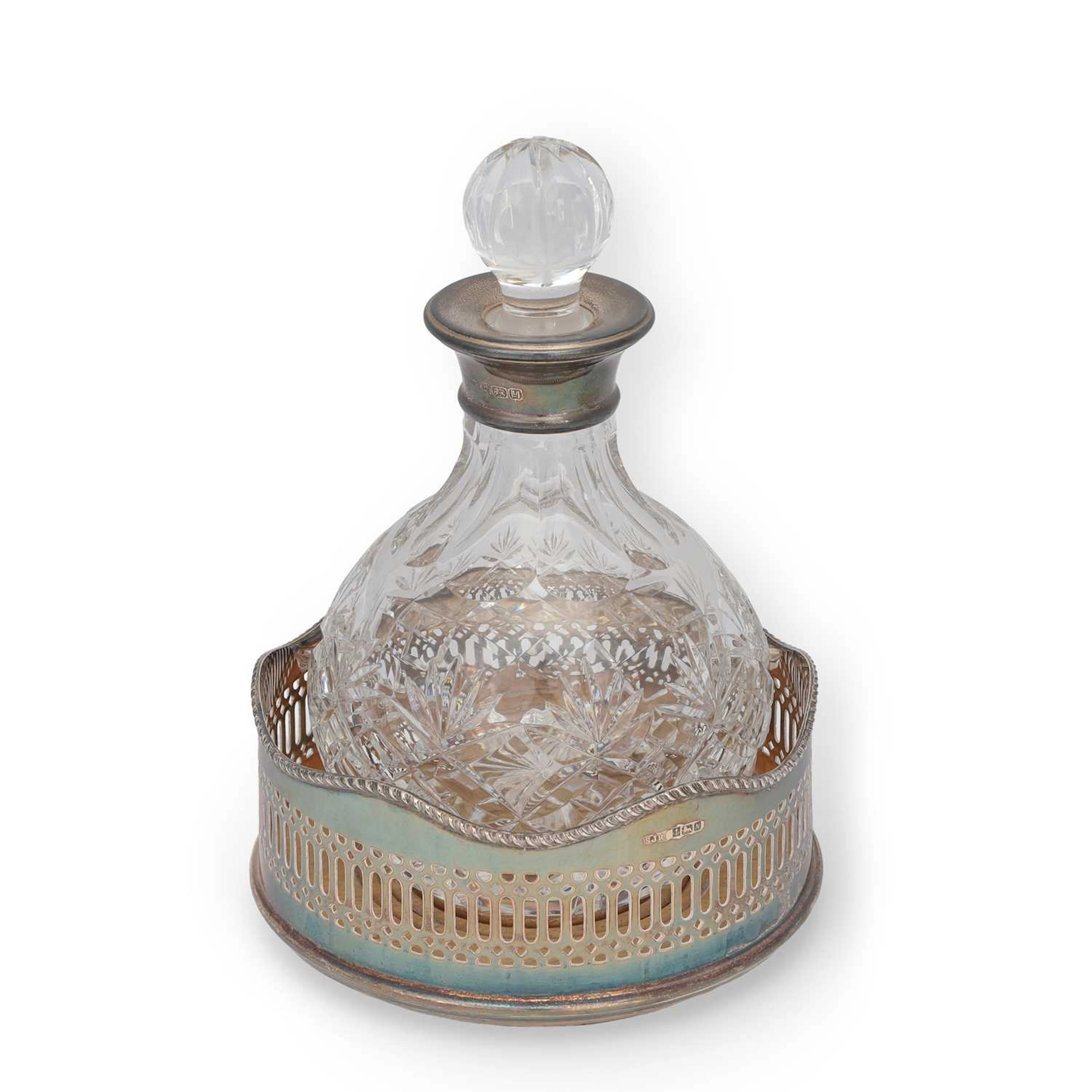 A SILVER-MOUNTED GLASS DECANTER AND A SILVER WINE COASTER