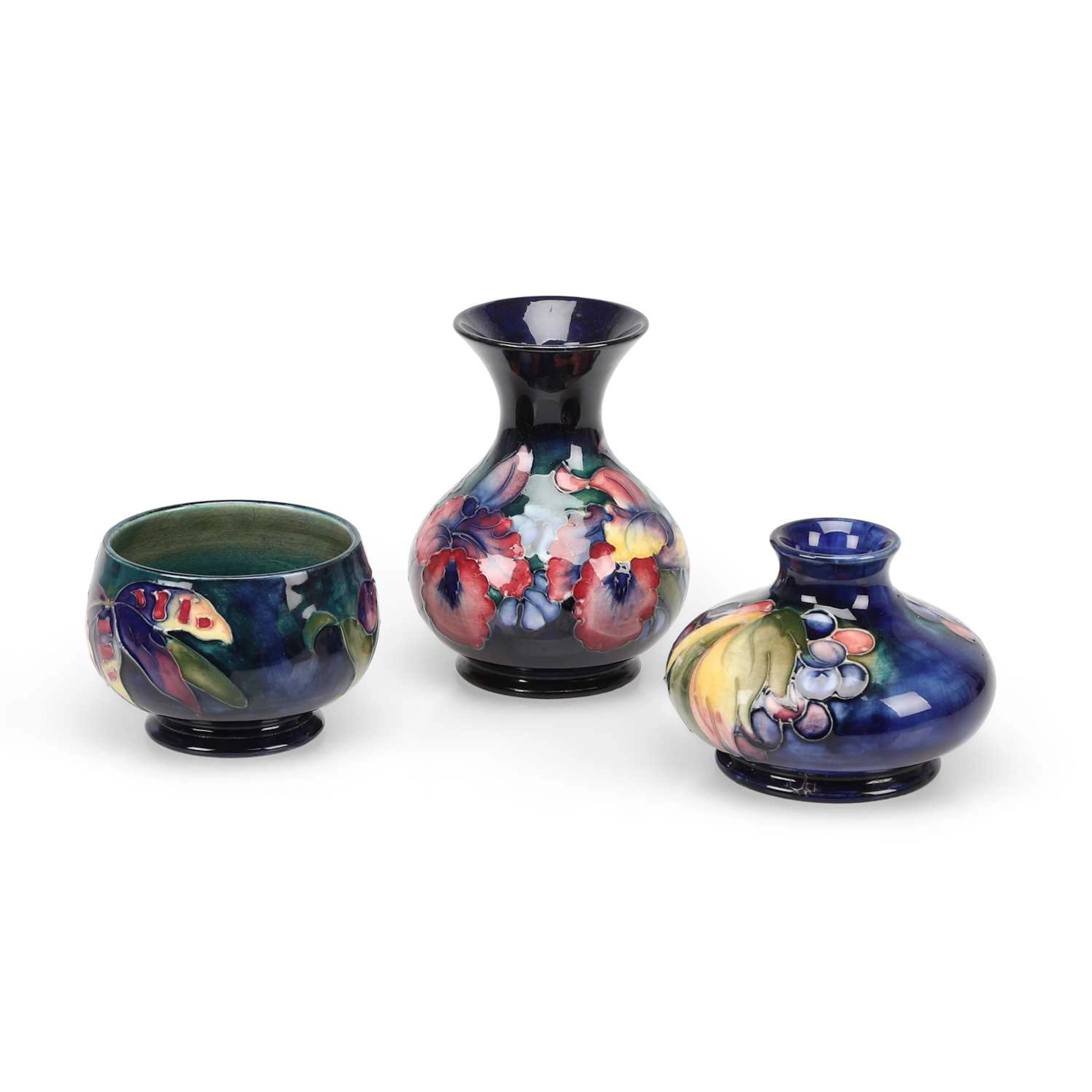 A MOORCROFT 'PANSY' VASE, A 'LEAF AND BERRY' VASE AND AN 'ORCHID' BOWL