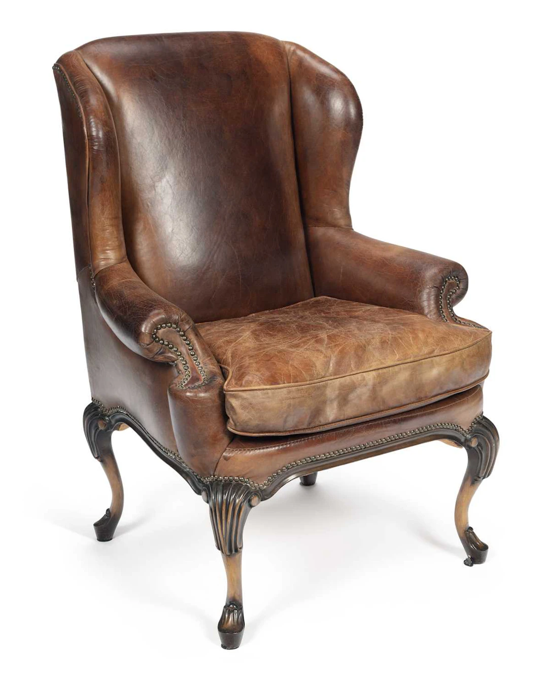 A LEATHER WING ARMCHAIR IN THE GEORGE II TASTE