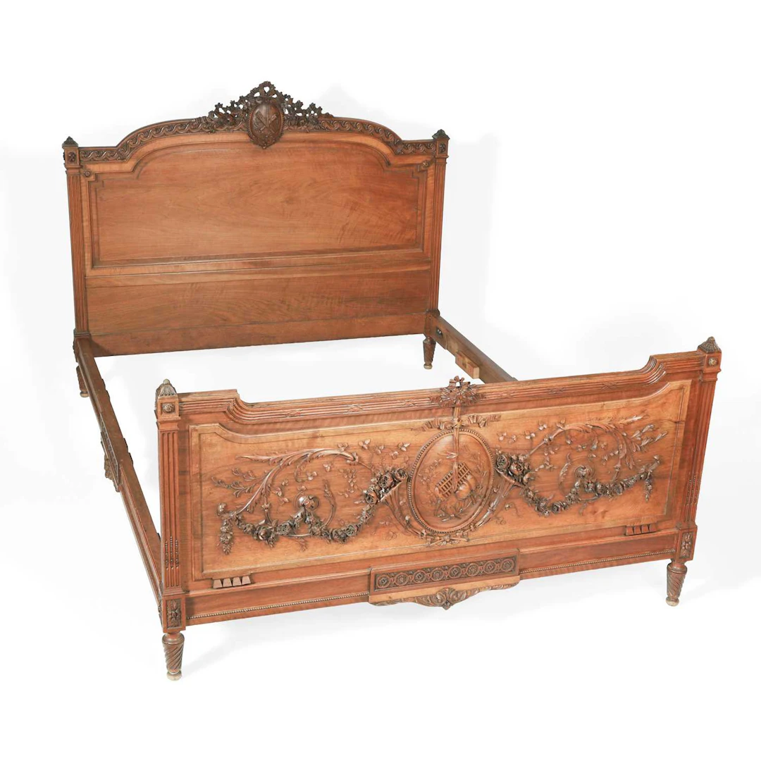 A FRENCH LOUIS XVI STYLE CARVED WALNUT BED