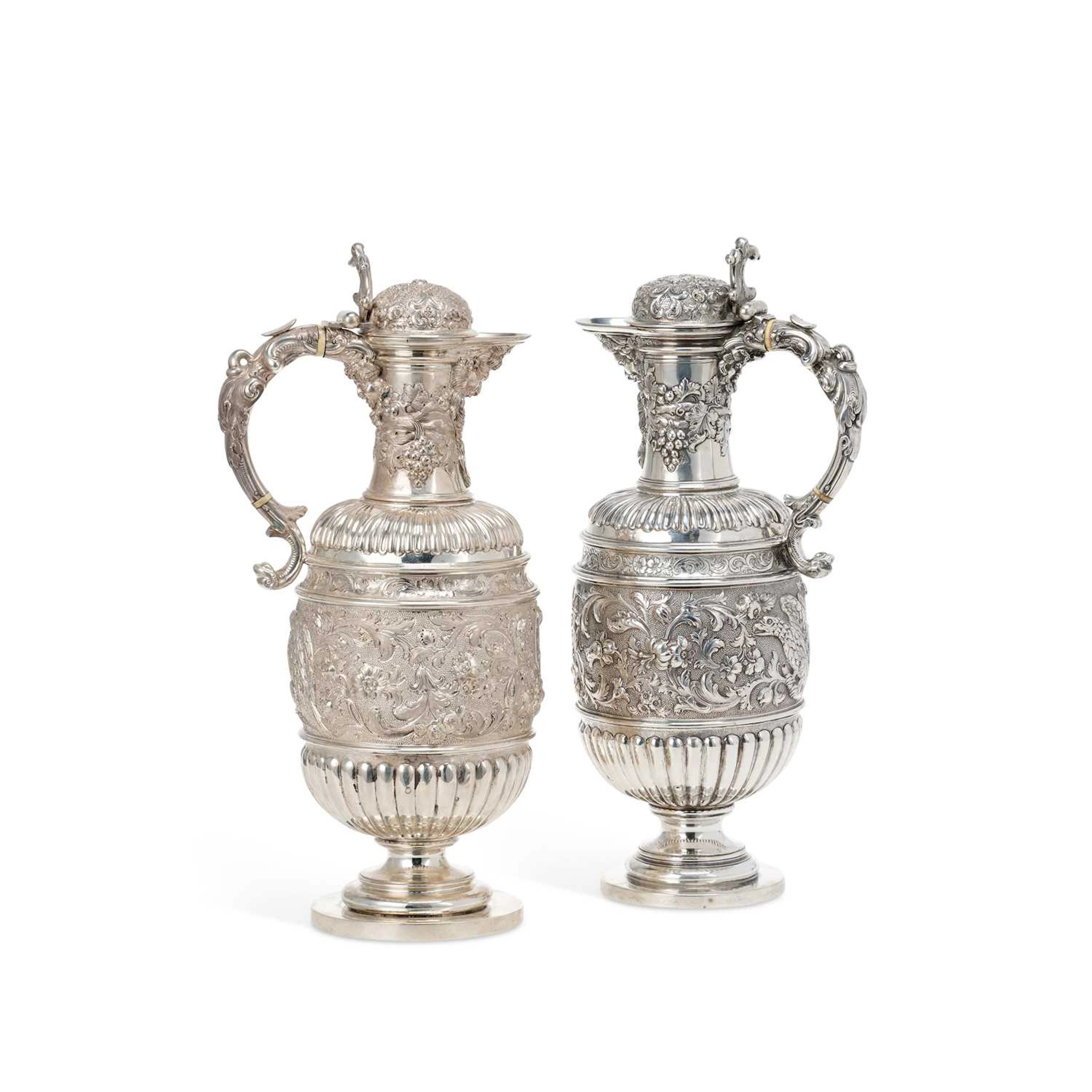 § A NEAR PAIR OF VICTORIAN SCOTTISH SILVER WINE/ CLARET JUGS